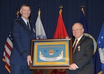 DLA Director Air Force Lt. Gen. Andy Busch presents retiring DLA General Counsel Fred Pribble a personalized DLA display flag at Pribble's May 3 retirement ceremony.