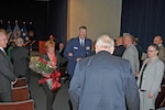 Ginger Pribble, who has been married to DLA General Counsel Fred Pribble for more than 30 years, is escorted from Pribble's retirement ceremony by DLA Director Air Force Lt. Gen. Andy Busch. Photo by Teodora Mocanu
