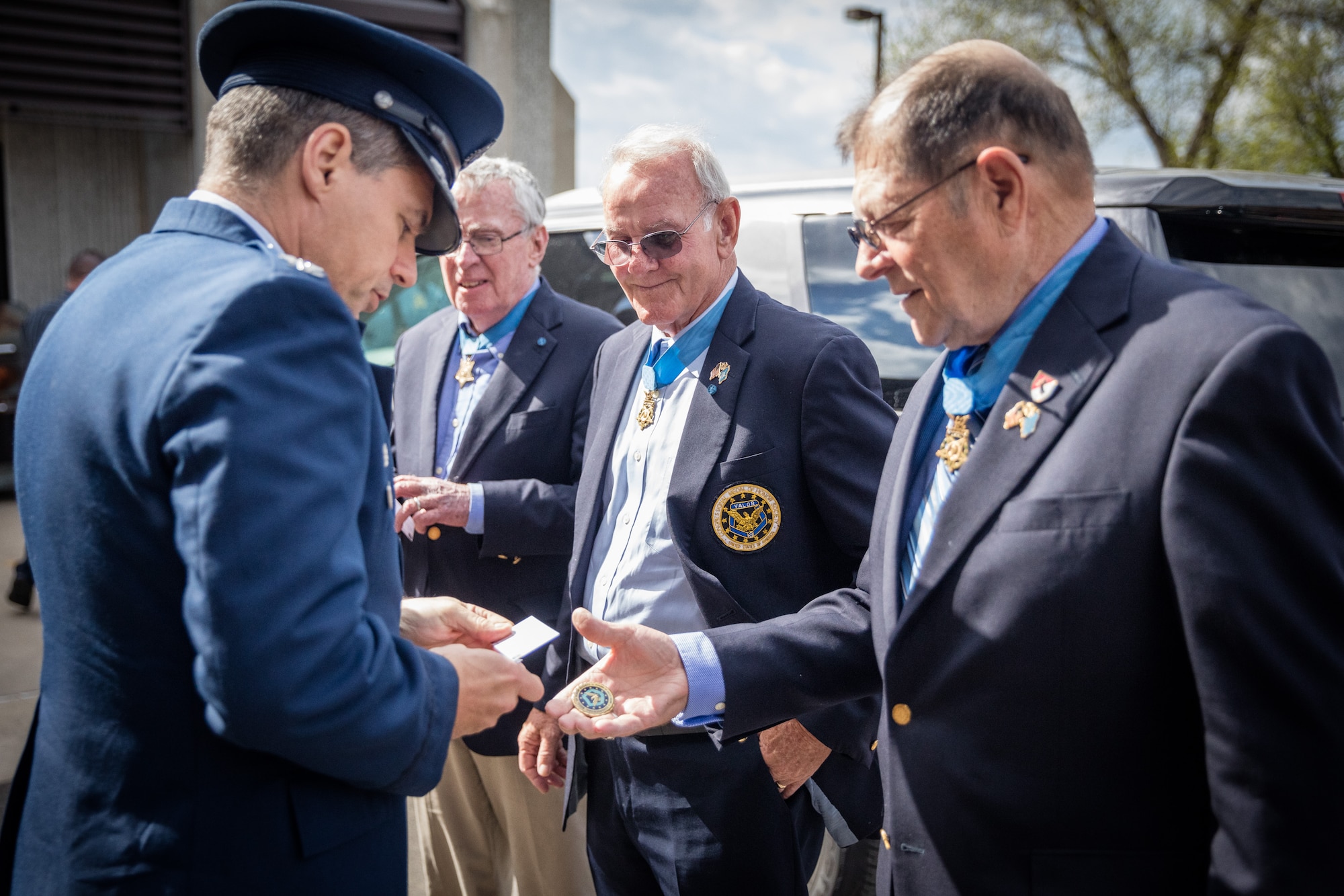 Medal of Honor Recipient, Mr. Harold "Hal" Fritz (right), exchanges coins with Col. Anthony Polashek (left), 934th Airlift Wing commander, upon his and fellow Medal of Honor Recipients' (center right), Mr. Robert Patterson and Mr. Thomas Kelley, arrivial at the Minneapolis-St. Paul Air Reserve Station, Minn.  The Medal of Honor Meet and Greet  honors military, law enforcement, and first responders affiliated with assisting the Twin Cities 2016 hosting of the Congressional Medal of Honor Convention, set for October of this year.  (U.S. Air Force photo by Shannon McKay)