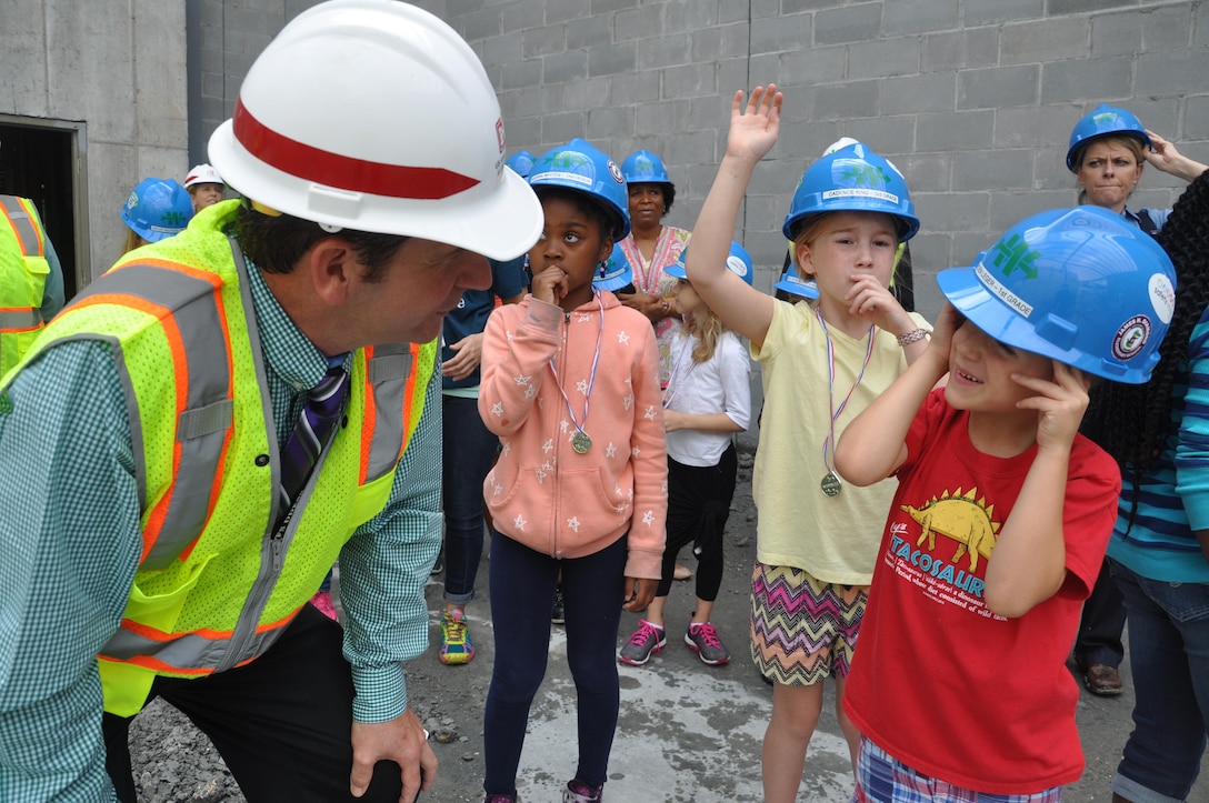 An Archer Western official answers a question from a Diamond Elementary School first-grader at the construction site of the new school May 3. Thirteen contest winners of Archer Western Contractor’s poster contest toured the site currently under construction at Fort Stewart, Georgia. Diamond students from kindergarten through sixth-grade submitted posters emphasizing safety themes in recognition of Safety Week celebrated May 2-6. The winning submissions were printed on the firm’s calendar that will be available throughout the Fort Stewart community. 