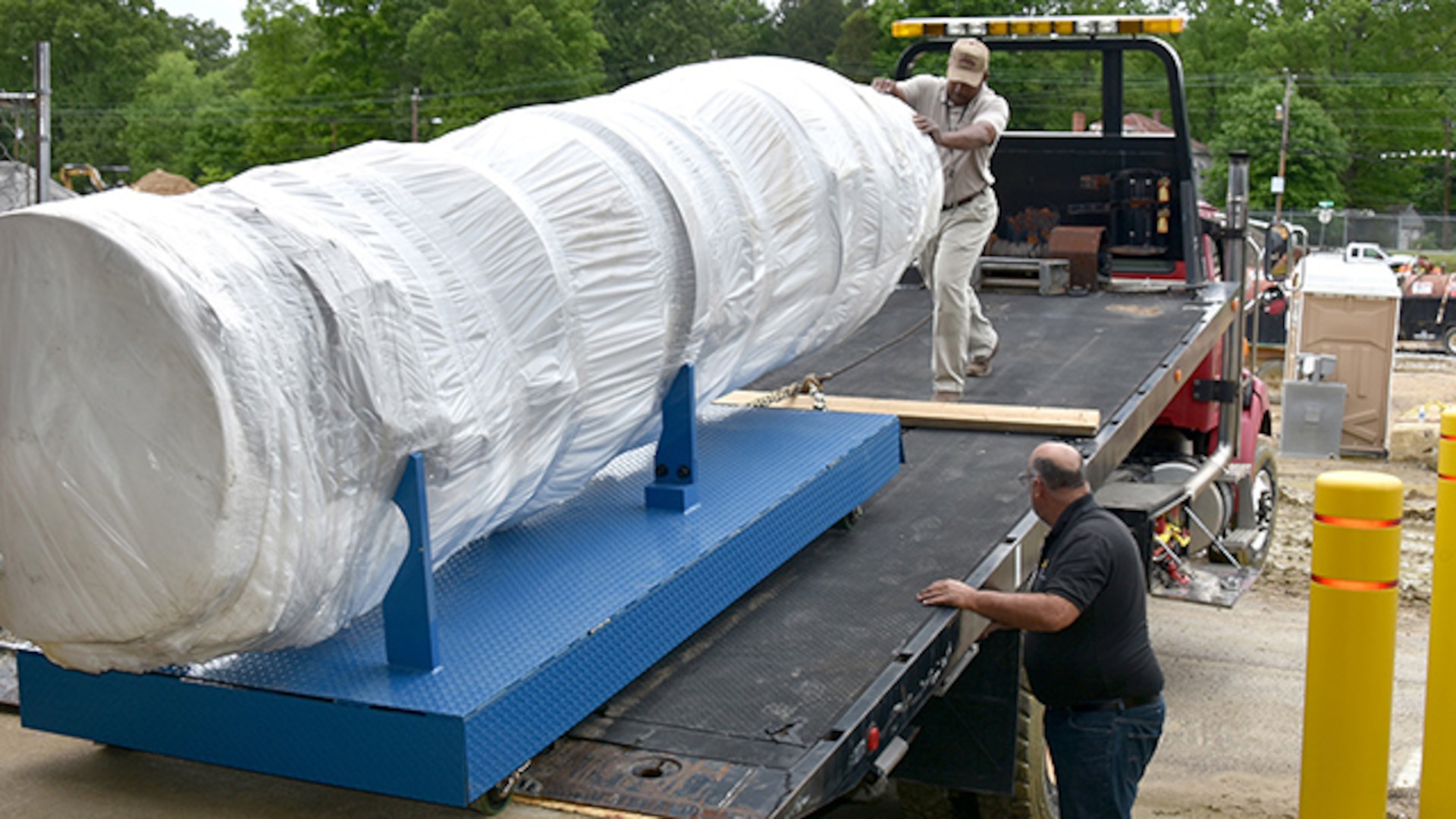 Glenn Cooper, chief of maintenance with DLA Installation Support at Richmond, Virginia, helps guide the F-100 Engine static display off the delivery truck May 4, 2016 while Randy Shortridge, chief of Industrial Equipment Services Section in installation support, oversees activity from the ground. The engine will be on display in the Frank B. Lotts Conference Center on Defense Supply Center Richmond. 