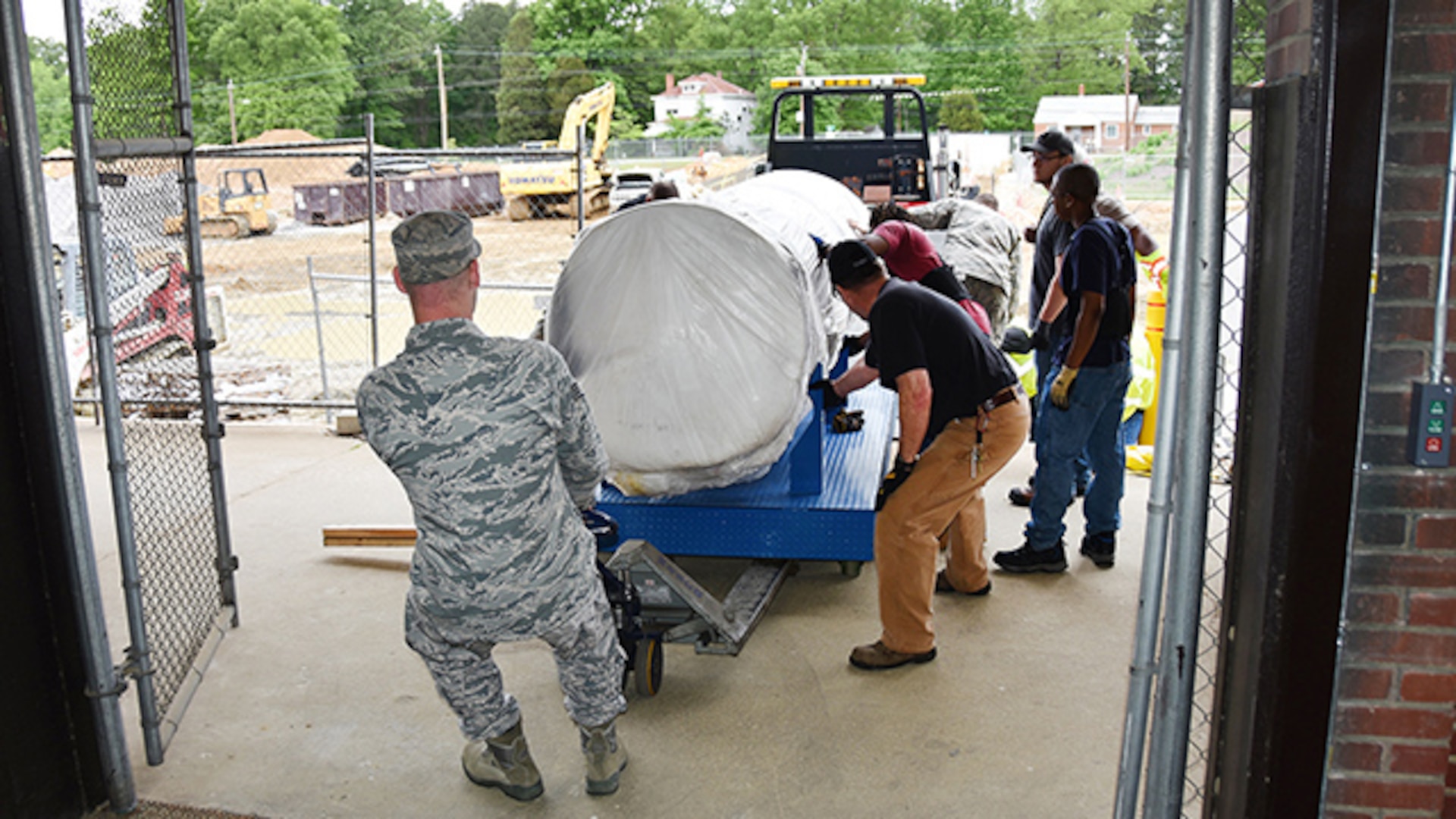 Airmen from the Oklahoma City Air Logistics Complex, in Oklahoma City, and employees from Defense Logistics Agency Installation Support at Richmond, Virginia, maneuver an F-100 Engine static display, weighing more than 3,000 pounds, into the Frank B. Lotts Conference Center on Defense Supply Center Richmond May 4, 2016. The installation’s newest static display is on loan from the Air Force Museum collection. 