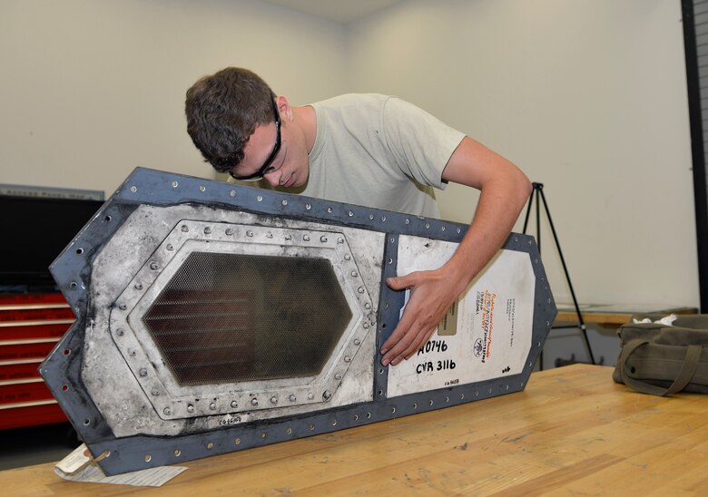 Senior Airman Tyler Quayle, 33rd Maintenance Squadron low observable maintenance journeyman, holds an F-35A Lightning II panel steady as he replaces a grommet at Eglin Air Force Base, Fla., April 28, 2016. The low observable maintenance shop conducts maintenance and inspects panels for structural damage daily. (U.S. Air Force photo/Senior Airman Andrea Posey)