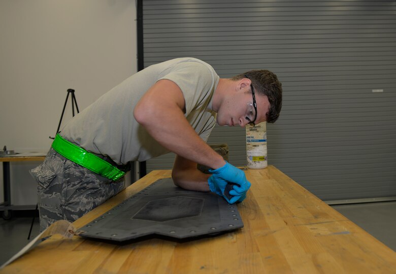 Senior Airman Tyler Quayle, 33rd Maintenance Squadron low observable maintenance journeyman, cleans the slot of an F-35A Lightning II panel before replacing a grommet at Eglin Air Force Base, Fla., Fla., April 28, 2016. The panel must be prepared with a cleaning agent to ensure adhesives can properly bond to the surface keeping parts in place. (U.S. Air Force photo/Senior Airman Andrea Posey)