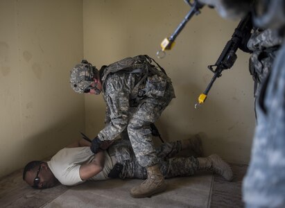 A team of U.S. Army Reserve military police Soldiers from the 56th Military Police Company (Combat Support), of Mesa, Arizona, find and detain a high-value target during a cordon and search training lane at Fort Hunter-Liggett, California, May 4. Approximately 80 units from across the U.S. Army Reserve, Army National Guard and active Army are participating in the 84th Training Command's second Warrior Exercise this year, WAREX 91-16-02, hosted by the 91st Training Division at Fort Hunter-Liggett, California. (U.S. Army photo by Master Sgt. Michel Sauret)