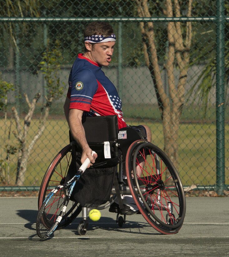 Retired Navy Seaman Austin Field prepares to hit a low return shot with retired Air Force Lt. Col. Dan Oosterhous, not shown, as they compete against the British team in the tennis quarterfinals during the 2016 Invictus Games in Orlando, Fla., May 6, 2016. DoD photo by Roger Wollenberg