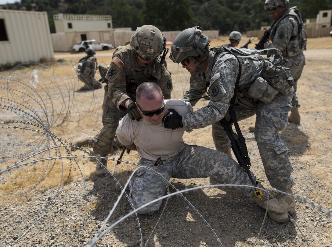 A team of U.S. Army Reserve military police Soldiers from the 56th Military Police Company (Combat Support), of Mesa, Arizona, detain a high-value target, played by Capt. Scott Little, with the 181st Infantry Brigade, of Winnipeg, Canada, during a cordon and search training lane at Fort Hunter-Liggett, California, May 4. Approximately 80 units from across the U.S. Army Reserve, Army National Guard and active Army are participating in the 84th Training Command's second Warrior Exercise this year, WAREX 91-16-02, hosted by the 91st Training Division at Fort Hunter-Liggett, California. (U.S. Army photo by Master Sgt. Michel Sauret)