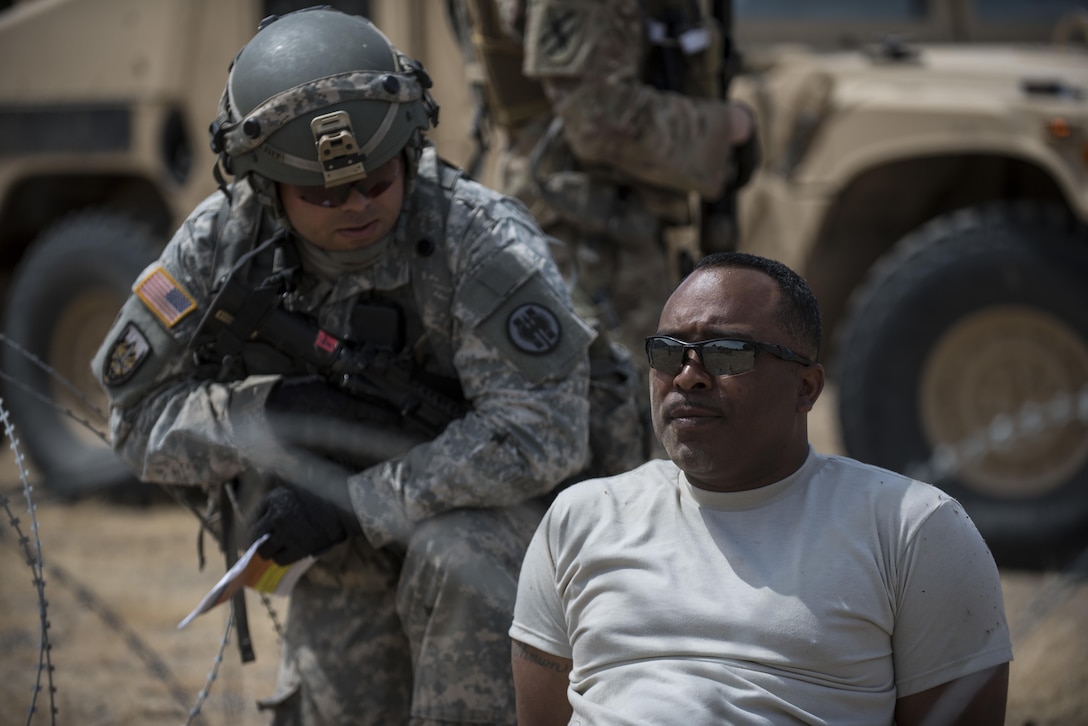 Sgt. 1st Class Malcolm Russell, a U.S. Army Reserve observer-coach trainer with the 91st Training Division, of Camp Parks, California, plays the role of a high-value target during a cordon and search training lane conducted by a platoon from the 56th Military Police Company (Combat Support), of Mesa, Arizona, at Fort Hunter-Liggett, California, May 4. Approximately 80 units from across the U.S. Army Reserve, Army National Guard and active Army are participating in the 84th Training Command's second Warrior Exercise this year, WAREX 91-16-02, hosted by the 91st Training Division at Fort Hunter-Liggett, California. (U.S. Army photo by Master Sgt. Michel Sauret)