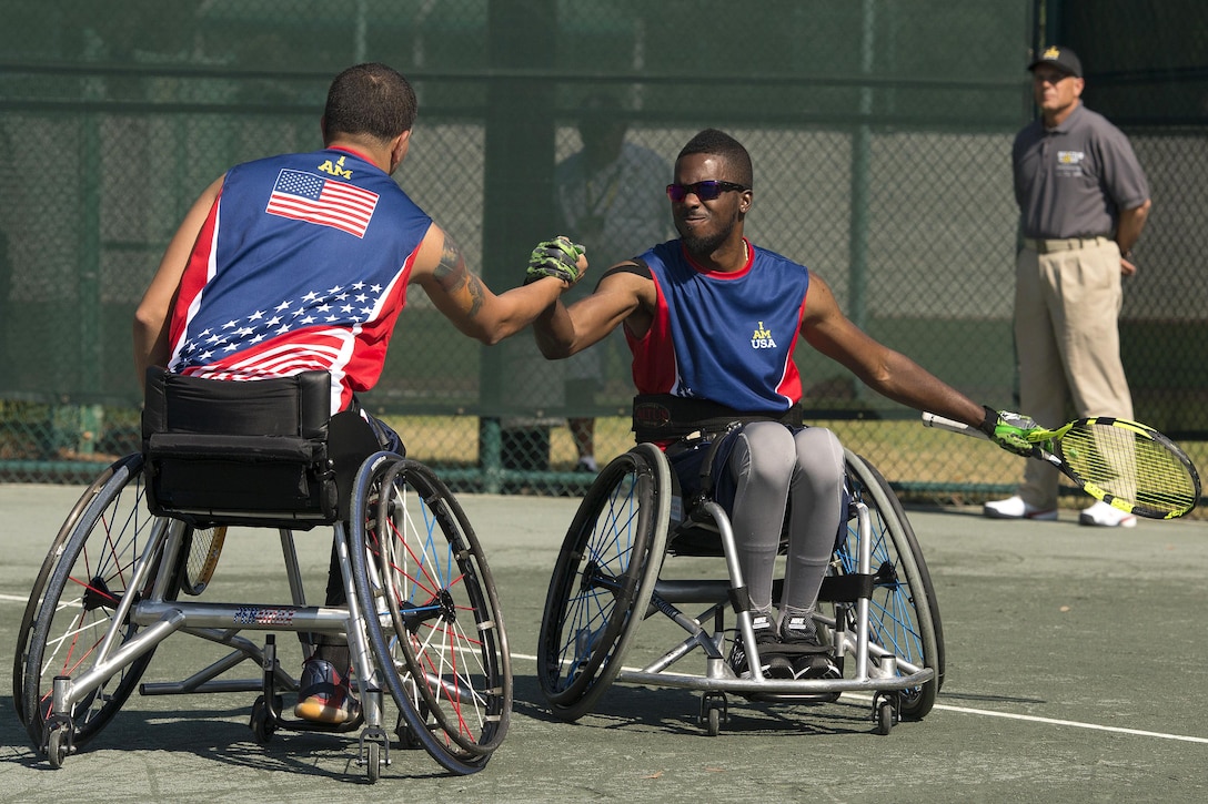 Retired Sgt. R.J. Anderson, right, and retired Navy Javier Rodriguez shake hands after scoring a point while competing against the Australians in the tennis quarterfinals during the 2016 Invictus Games in Orlando, Fla., May 6, 2016. DoD photo by Roger Wollenberg