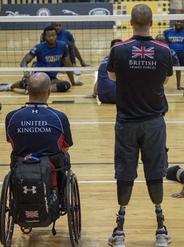 Two British wounded warrior athletes watch fellow team members practice sitting volleyball at the 2016 Invictus Games in Orlando, Fla., May 6, 2016. Air Force photo by Senior Master Sgt. Kevin Wallace