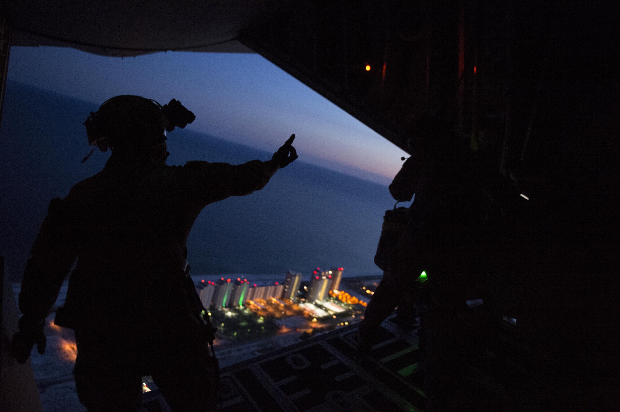 Staff Sgt. Brendan McNall, 9th Special Operations Squadron loadmaster, signals to 21st Special Tactics Squadron combat controllers before conducting a static-line water jump from a MC-130J Commando II during Emerald Warrior May 5, 2016, over Hurlburt Field, Fla. (U.S. Air Force photo by Staff Sgt. Matthew B. Fredericks)