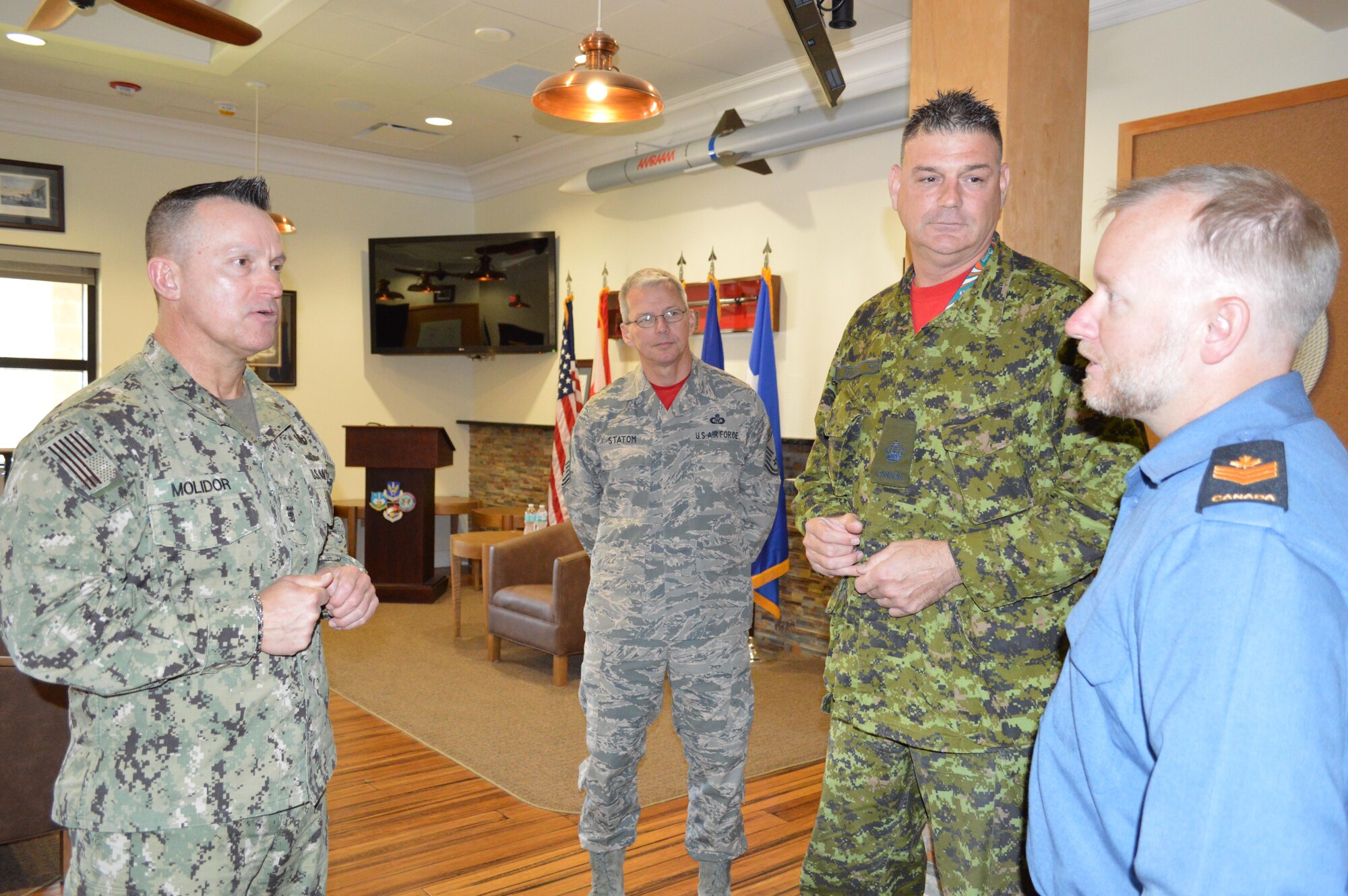 Navy Fleet Master Chief Terrence Molidor, North American Aerospace Defense Command and United States Command Senior Enlisted Leader, talks with Royal Canadian Navy PO2 Brian Fraser about his experiences here after a May 6 senior enlisted call as Royal Canadian Air Force WO Darren Guitard and U.S. Air Force Chief Master Sgt. Billie Statom listen. During his visit, Molidor provided audience members with a current command perspective and answered questions from the audience. (Photo by Mary McHale)