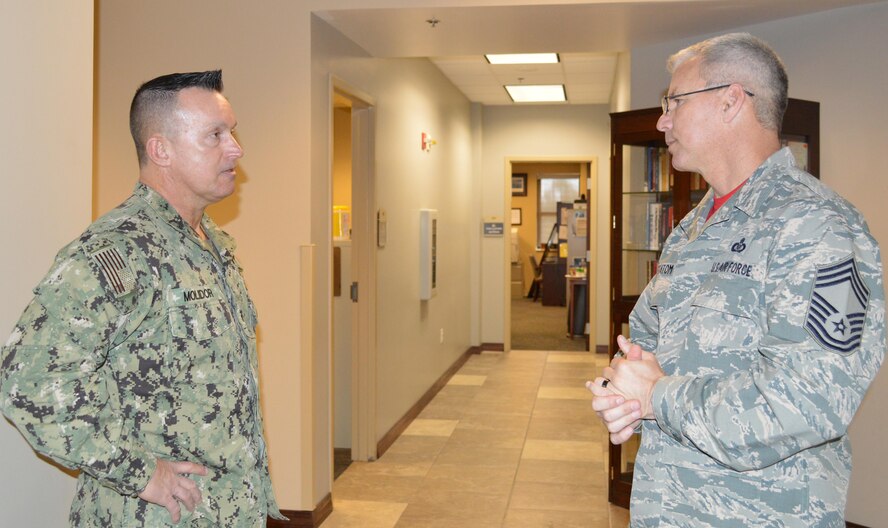 Navy Fleet Master Chief Terrence Molidor, North American Aerospace Defense Command and United State Command Senior Enlisted Leader, talks with U.S. Air Force Chief Master Sgt. Billie Statom Jr., 1st Air Force (Air Forces Northern) Operations Directorate Chief Enlisted Manager, prior to a senior enlisted call May 6 at the Killey Center here. During his visit, Mollidor provided audience members with a current command perspective and answered questions from the audience. (Photo by Mary McHale)