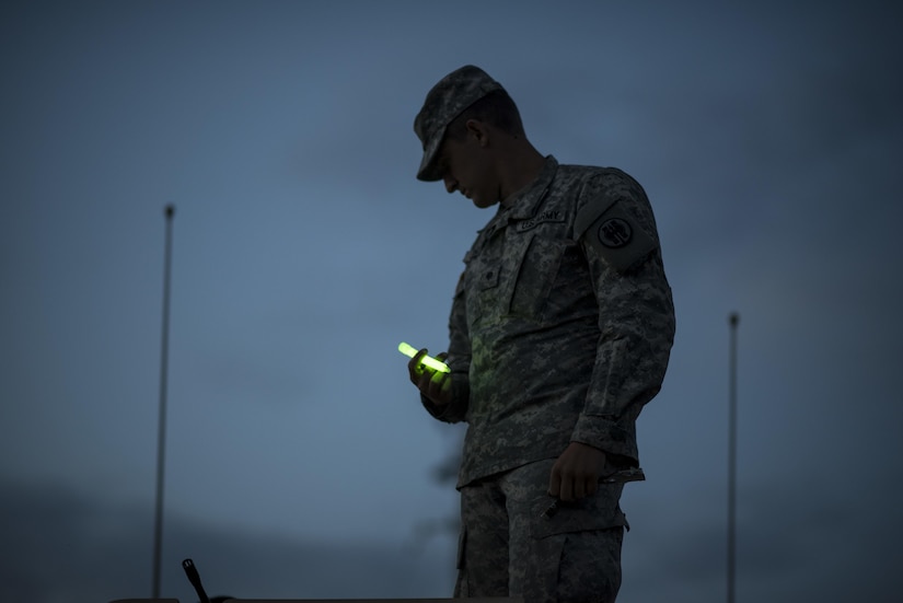 Spc. Bradley Schopf, a U.S. Army Reserve military police Soldier with the 341st MP Company, of Tracy, Califonia, holds a glow stick as he prepares for a mounted crew-served weapon night fire qualification table at Fort Hunter-Liggett, California, May 3. The 341st MP Co. is one of the first units in the Army Reserve conducting a complete 6-table crew-serve weapon qualification, which includes firing the M2, M249 and M240B machine guns both during the day and night. (U.S. Army photo by Master Sgt. Michel Sauret)