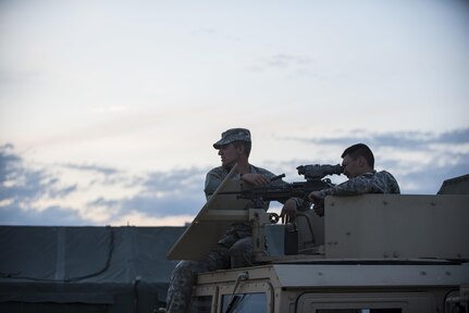 Pfc. Ryan Joe, U.S. Army Reserve military police Soldiers from the 341st MP Company, of South San Francisco, California, looks down the night vision scope of his assigned M249 Squad Automatic Weapon with the help of Spc. Bradley Schopf, of Tracy, California, as they prepare for a mounted crew-served weapon night fire qualification table at Fort Hunter-Liggett, California, May 3. The 341st MP Co. is one of the first units in the Army Reserve conducting a complete 6-table crew-serve weapon qualification, which includes firing the M2, M249 and M240B machine guns both during the day and night. (U.S. Army photo by Master Sgt. Michel Sauret)