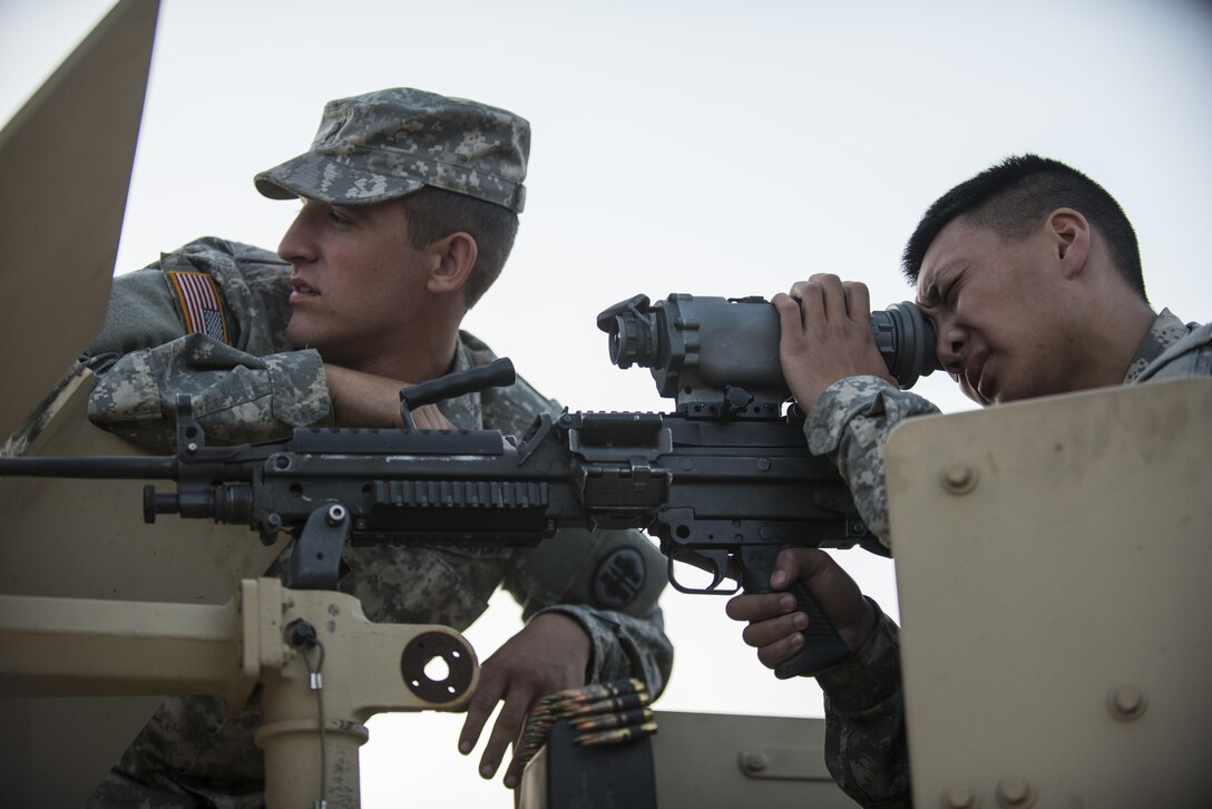 Pfc. Ryan Joe, U.S. Army Reserve military police Soldiers from the 341st MP Company, of South San Francisco, California, looks down the night vision scope of his assigned M249 Squad Automatic Weapon with the help of Spc. Bradley Schopf, of Tracy, California, as they prepare for a mounted crew-served weapon night fire qualification table at Fort Hunter-Liggett, California, May 3. The 341st MP Co. is one of the first units in the Army Reserve conducting a complete 6-table crew-serve weapon qualification, which includes firing the M2, M249 and M240B machine guns both during the day and night. (U.S. Army photo by Master Sgt. Michel Sauret)