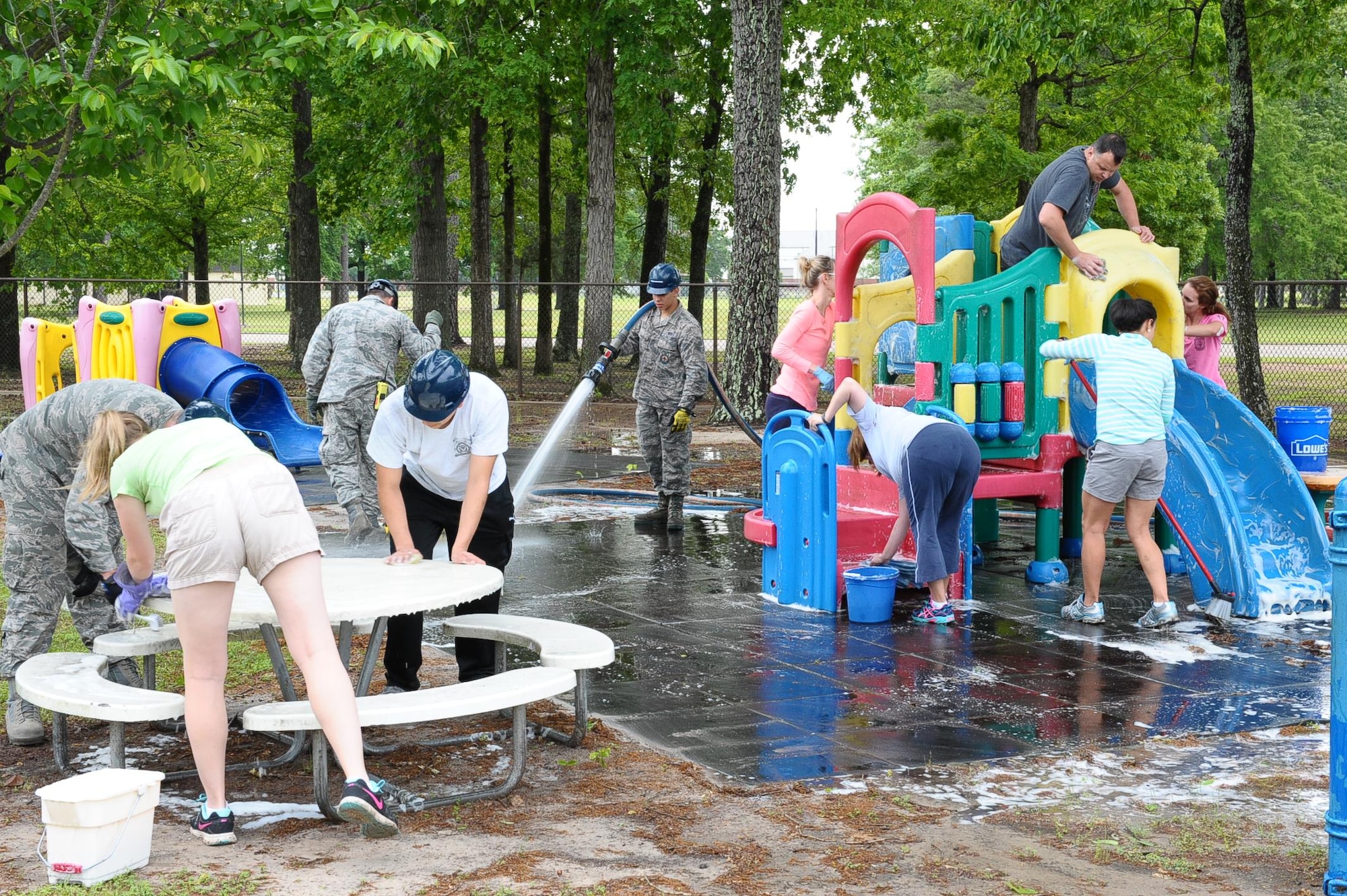 Spouses, Airmen, and other dependents volunteer their Saturday morning to clean up the Lil-BLAZEr Park located across the street from the Bowling Alley April 30 at Columbus Air Force Base, Mississippi. Several Team BLAZE members brought buckets, sponges and soap while the Fire Station provided the water to help power clean the playground. (U.S. Air Force photo/Senior Airman Kaleb Snay)