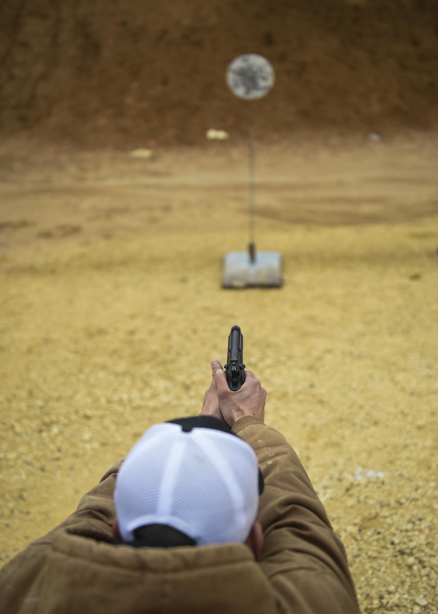 Capt. James Ramirez, a combat systems officer with the 19th Special Operations Squadron, practices drawing and firing his M9 pistol from a concealed carry position at a firing range near Baker, Fla., Feb. 24, 2016. The irregular nature of Air Force Special Operations Command’s mission sometimes require air crews to operate in austere conditions downrange, prompting the creation of the Air Commando Field Skills Course. During the second stage of pistol training, Airmen learned conceal carry as well as moving and shooting techniques. (U.S. Air Force photo by Airman 1st Class Kai White)