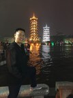 Capt. Raymond Zhang, 22nd Airlift Squadron pilot, poses for a photo in Guilin, China, with illuminated pagodas in the background. Zhang went to China in March to serve as a translator as par of an Air War College visit to the Asian nation. (Courtesy photo)