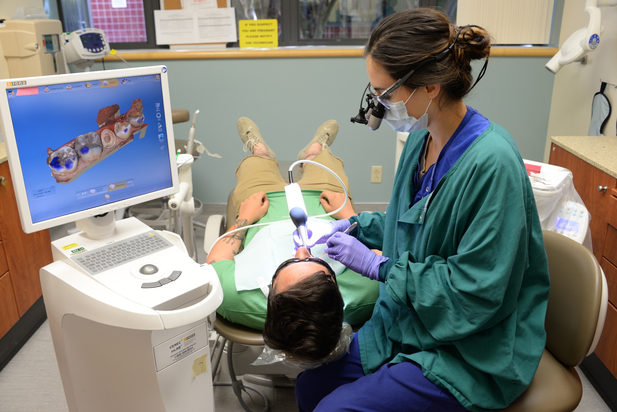 Capt. Eileen Welch, 60th DS advanced education in general dentistry resident, uses the inter oral digital scan for a cerec cad/cam crown May 2 at Travis Air Force Base, California. The patient is treated by using the crown that went through several steps in the dental clinic before it was placed on the patient's tooth. (U.S. Air Force photo by Senior Airman Amber Carter)