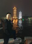Capt. Raymond Zhang, 22nd Airlift Squadron pilot, poses for a photo in Guilin, China, with illuminated pagodas in the background. Zhang went to China in March to serve as a translator as part of an Air War College visit to the Asian nation. (Courtesy photo)