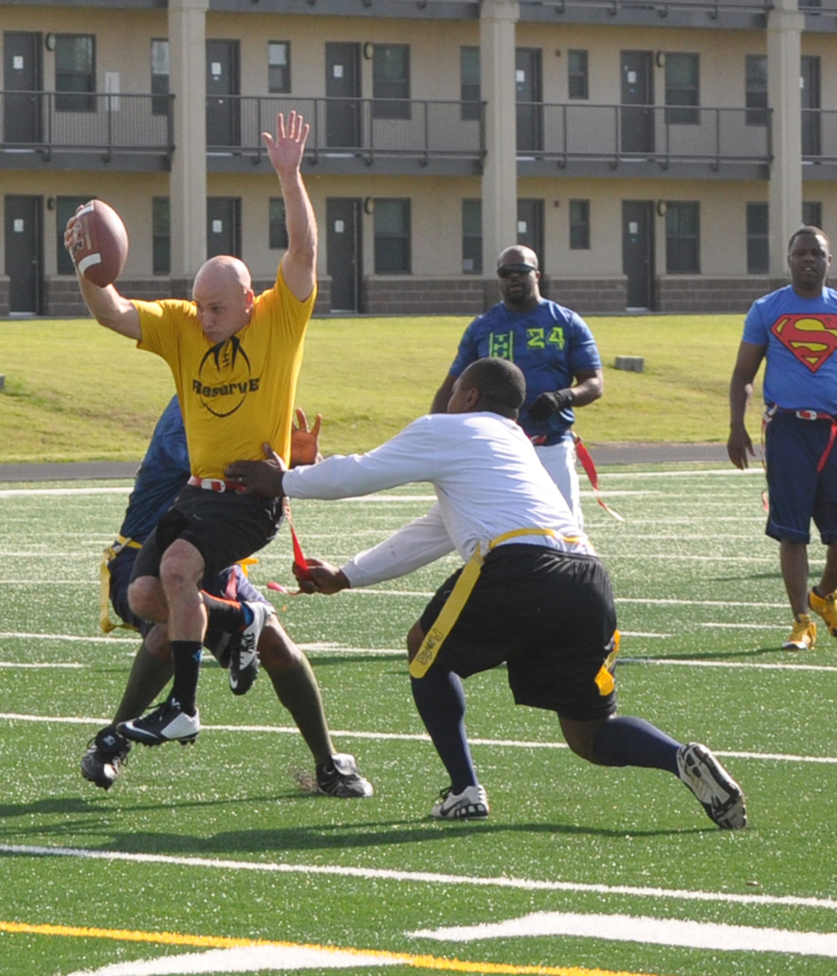 Reserve Gold quarterback Jeff Inferrere leaps through an SCMS Thunder gauntlet last Tuesday at the athletic field north of the dorms. Reserve Gold won 17-0 in the first game of the Spring Flag Football League playoffs. Reserve Gold will battle No. 1 seed Med Group at 5:15 p.m. Tuesday. (Air Force photo by John Parker/Released)