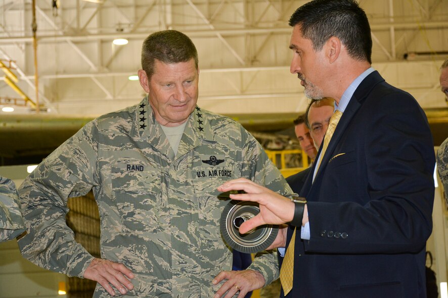 John R. Sneden, Air Force Life Cycle Management Center Propulsion Sustainment Division chief, discusses F107 engine 
supply and production supportability issues with Gen. Robin Rand, commander, Air Force Global Strike Command, during the general’s visit to Tinker Air Force Base, April 26. Mr. Sneden is holding a part of the F107 High Pressure Turbine. The F107 is used to power the Air Force’s cruise missile inventory. (Air Force photo by Darren D. Heusel/Released)
