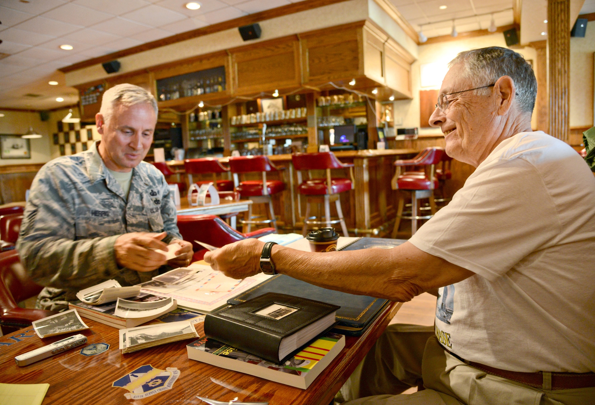 Master Sgt. David Herrig, with the Air Force Sustainment Center Contracting Directorate, and retired Master Sgt. Pete Piazza met at the Tinker Club on April 26 to swap stories and share memorabilia. Mr. Piazza served at Bien Hoa Air Base, Vietnam in 1968, the same time Sgt. Herrig’s father, Tech. Sgt. Delbert W. Herrig, also served there. (Air Force photo by Kelly White/Released)