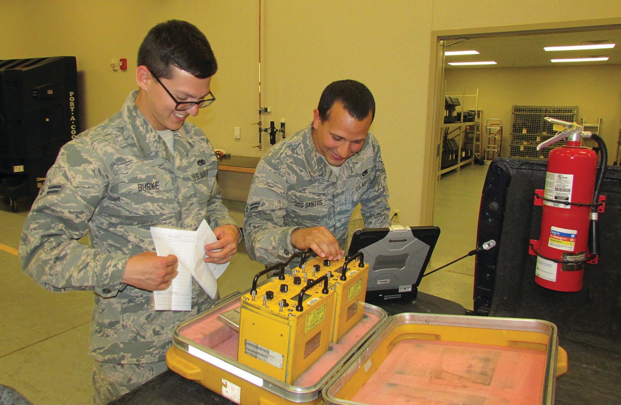 Airmen 1st Class David Dos Santos, left, and Caleb Burke test batteries at the 58th Maintenance Squadron shop. The duo are from the same hometown and completed training together and are now assigned to the same duty station. (Photo by Argen Duncan)