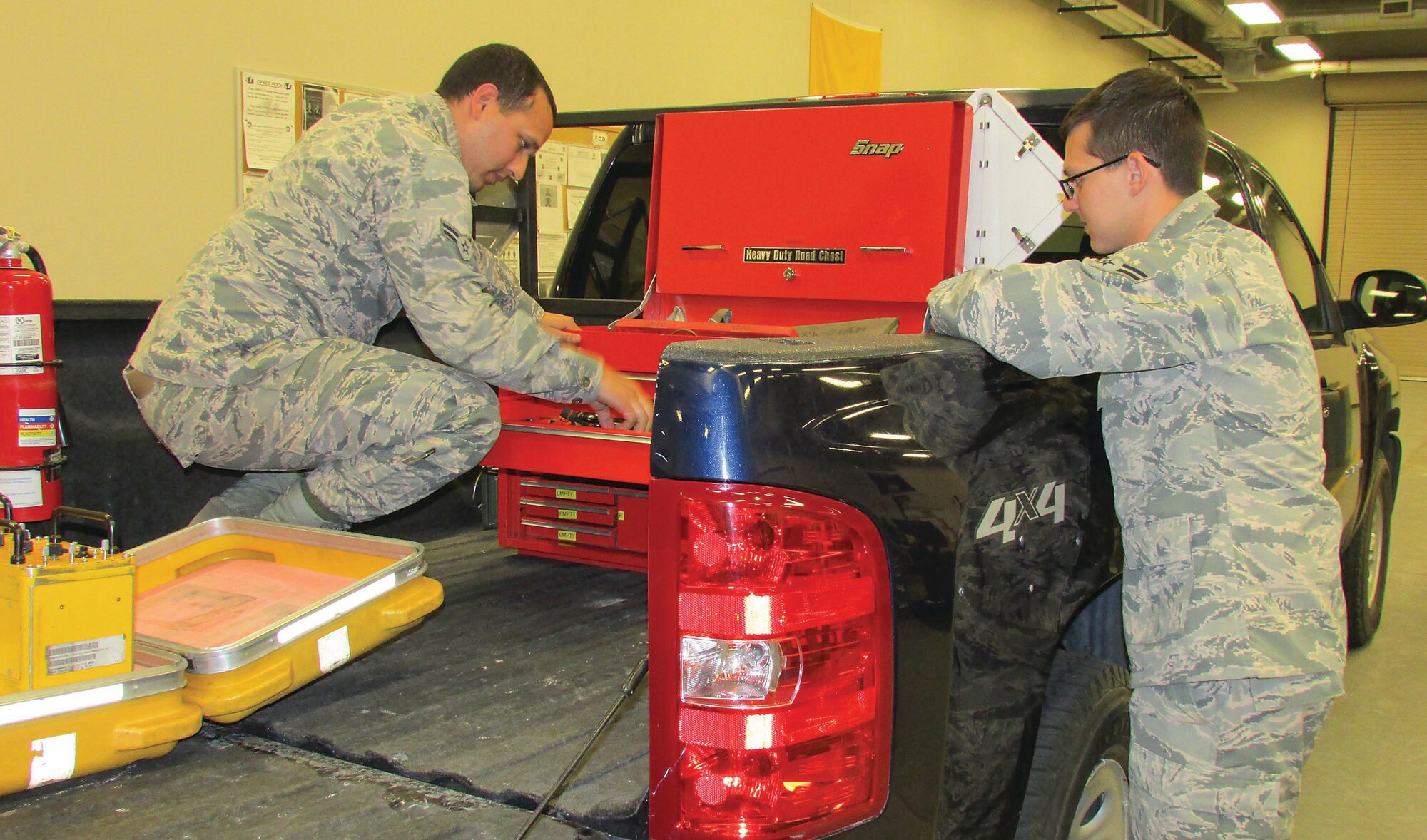 Airmen 1st Class David Dos Santos, left, and Caleb Burke look over tools at the 58th Maintenance Squadron shop. The duo are from the same hometown and completed training together and are now assigned to the same duty station. (Photo by Argen Duncan)