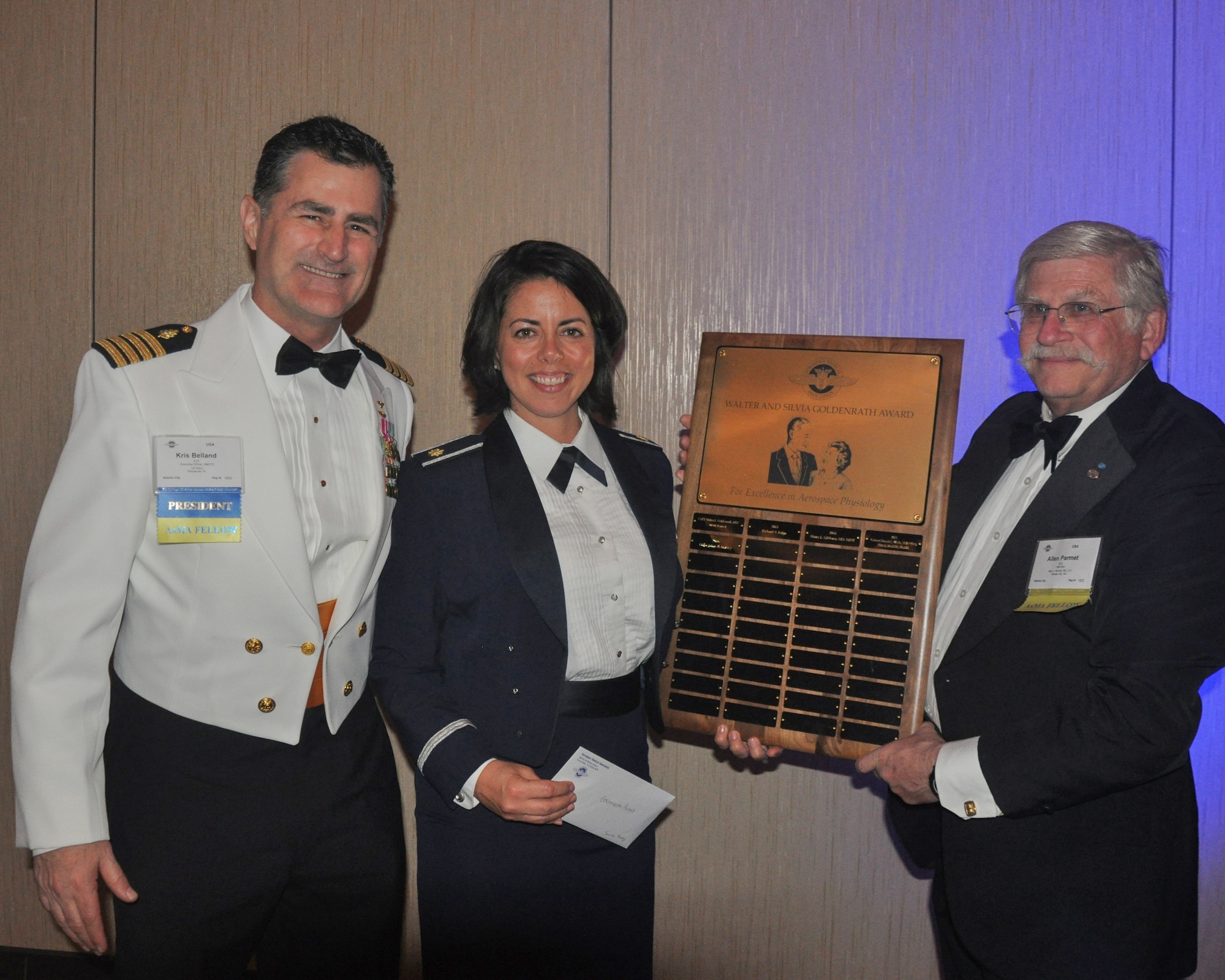Air Force Maj. Jamie R. Harvey, center,  is joined by Navy Capt. (Dr.) Kris Belland, president of the Aerospace Medical Association, left, and Dr. Allen Parmet, AsMA Executive Council member, right, following Harvey’s receipt of the Walter and Sylvia Goldenrath Award for outstanding contributions to the field of aerospace physiology. The award was presented during the AsMA honors ceremonies April 28, 2016, in Atlantic City, N.J. Harvey, a human factors physiologist in Headquarters Air Force Safety, Washington, D.C., was recognized for her investigation of the evidence base for human performance consequences of shift work. Her work was cited for the selection and evaluation of 26-peer-reviewed research papers and more than 80 abstracts leading to evidence-based recommendations for shift length, shift change speed and directions, and worker performance. (Courtesy photo)