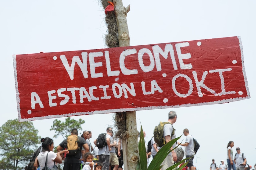 A sign welcomes the 158 U.S. service members and civilians from Joint Task Force-Bravo to Montaña La Oki, a small village located in the mountains east of Comayagua, Honduras, where 172 families awaited the arrival of the participants of Chapel Hike 67 and the 3,000 pounds of food they carried 3.4 miles up the mountain April 30, 2016. In addition to the ton-and-a-half of food, which was packed into 150 bags containing 20 pounds apiece by volunteers two nights prior to the trek, many hikers brought their own additional treats and toys to give to the dozens of children they met at the top of the mountain, which was 4,406 feet above sea level. Chapel Hikes are designed to provide a practical way for JTF-Bravo members to engage and partner with local communities to provide support to surrounding villages in need of food and supplies.  (U.S. Air Force photo by Capt. David Liapis/Released)