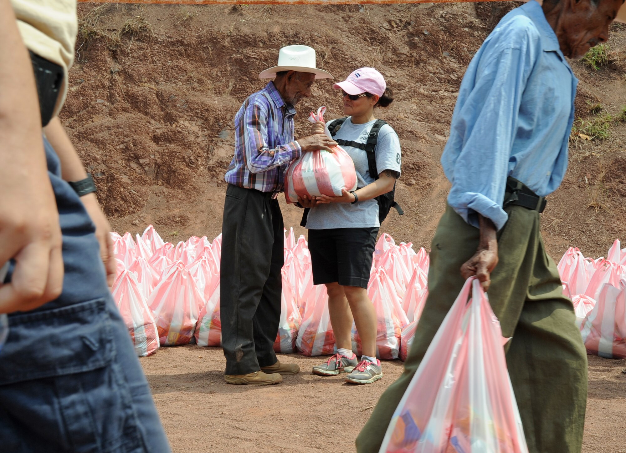 A villager from Montaña La Oki, located 4,406 feet above sea level in the mountains east of Comayagua, Honduras, receives one of the 150 bags of food, weighing 20 pounds apiece, carried up the mountain by 158 military and civilian members of Joint Task Force-Bravo and volunteer firefighters from the local area who hiked 7.4 miles roundtrip to deliver a total of 3,000 pounds of food to 172 families in the village during Chapel Hike 67, April 30, 2016. Chapel hikes, which have been taking place since 2003, contribute to the JTF’s mission objective of building partnership capacity with the Hondurans, as well as providing an opportunity for service members to show compassion and kindness to others who are in need. (U.S. Air Force photo by Capt. David Liapis/Released)
