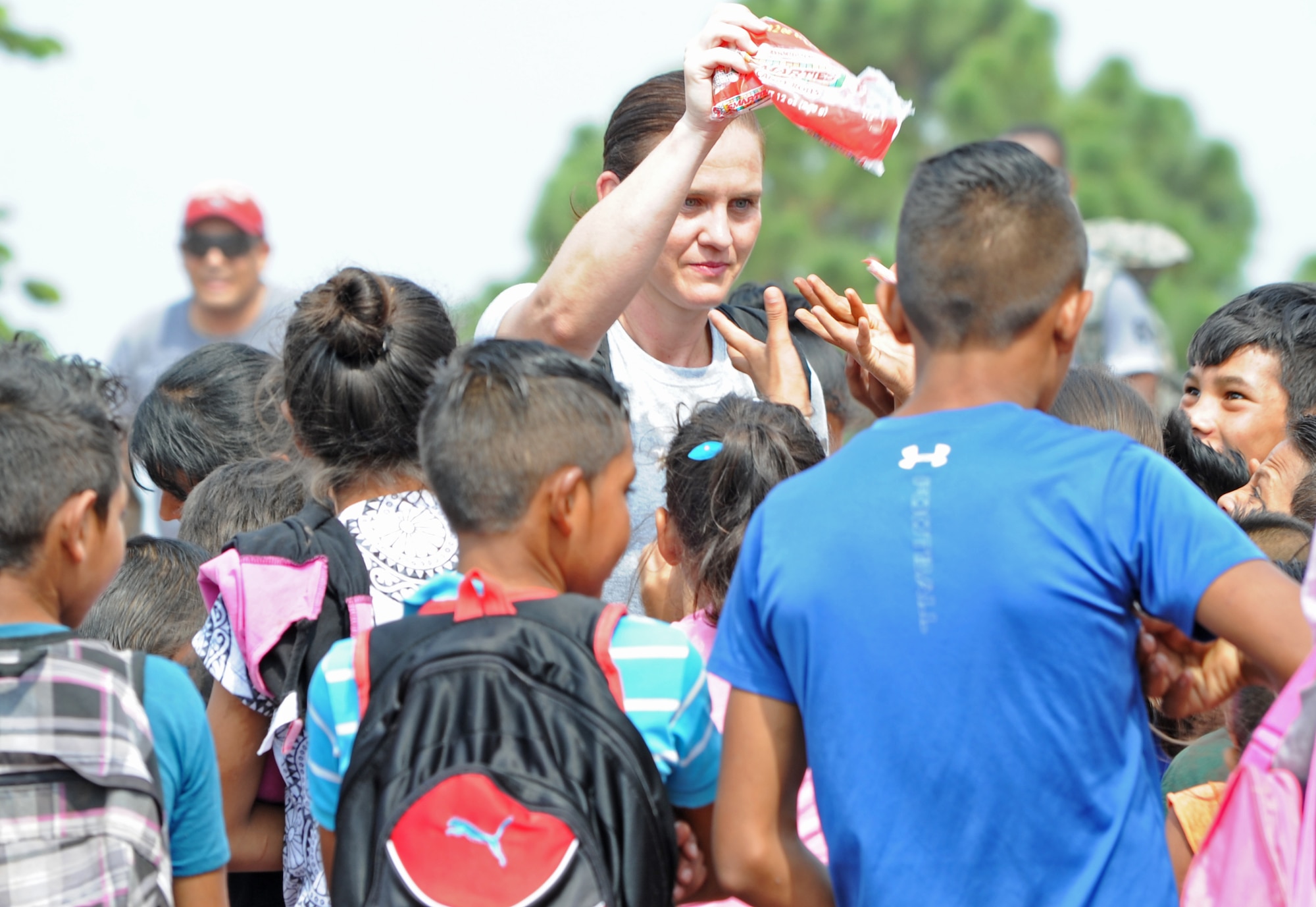 A member of Joint Task Force-Bravo hands out candy to some of the dozens of children of Montaña La Oki, a small village located in the mountains east of Comayagua, Honduras, during Chapel Hike 67, April 30, 3016. More than 158 military and civilian members of Joint Task Force-Bravo and volunteer firefighters from the local area hiked 7.4 miles roundtrip to deliver 3,000 pounds of food to 172 families in the village. Chapel Hikes provide an opportunity for service members to contribute to the JTF’s mission objective of building partnership capacity with the Hondurans as well as to show compassion and kindness to others who are in need. (U.S. Air Force photo by Capt. David Liapis/Released)