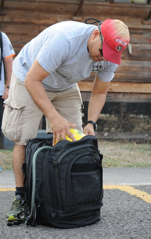 U.S. Air Force Capt. Jesus Lopez, Joint Task Force-Bravo personnel officer, fits a soccer ball into his backpack before departing for Chapel Hike 67, April 30, 2016, Soto Cano Air Base, Honduras. Lopez gave the ball to the children of Montaña La Oki, a small village located in the mountains east of Comayagua, Honduras. During the visit, U.S. service members had the opportunity to watch local school children perform cultural dances, play soccer and hand out 150 bags of food to villagers as well as some Hondurans who traveled to the location on horseback from the surrounding mountains.  (U.S. Air Force photo by Capt. David Liapis/Released)