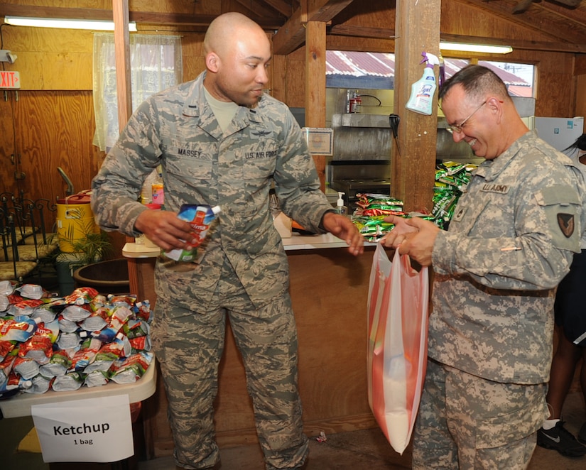 U.S. Air Force Lt. Kyle Massey, Joint Task Force-Bravo communications officer, and U.S. Army Sgt. 1st Class Jerome Sonnier, JTF-Bravo contract specialist, load one of 150 bags of food, weighing 20-pounds apiece once full, in preparation for Chapel Hike 67 at the chapel at Soto Cano Air Base, Honduras, April 28, 2016. Members of the Soto Cano community donated $3,150 in order to purchase the 3,000 pounds of food that would be delivered to the people of Montaña La Oki, a small village located in the mountains east of Comayagua, Honduras. (U.S. Air Force photo by Capt. David Liapis/Released)