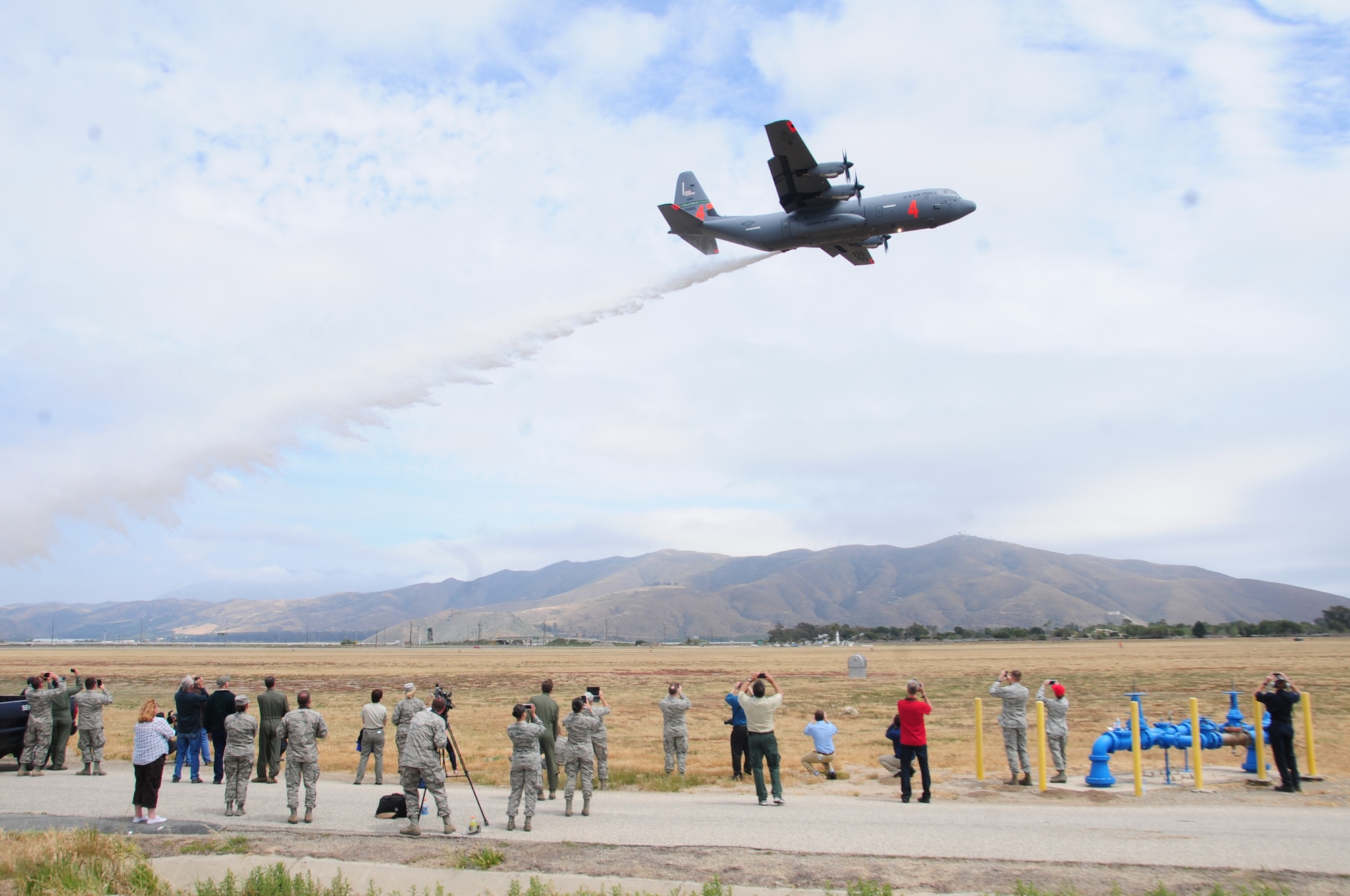 California Air National Guard's C-130J drops water near onlookers during MAFFS annual certification and training at the 146th Airlift Wing in Port Hueneme, California on May 4, 2016. Air National Guard and Reserve units from across the U.S. convened for MAFFS (Modular Airborne Fire Fighting Systems)annual certification and training this week to prepare for the upcoming fire season in support of U.S. Forest Service. (U.S. Air National Guard photo by Senior Airman Madeleine Richards/Released)
