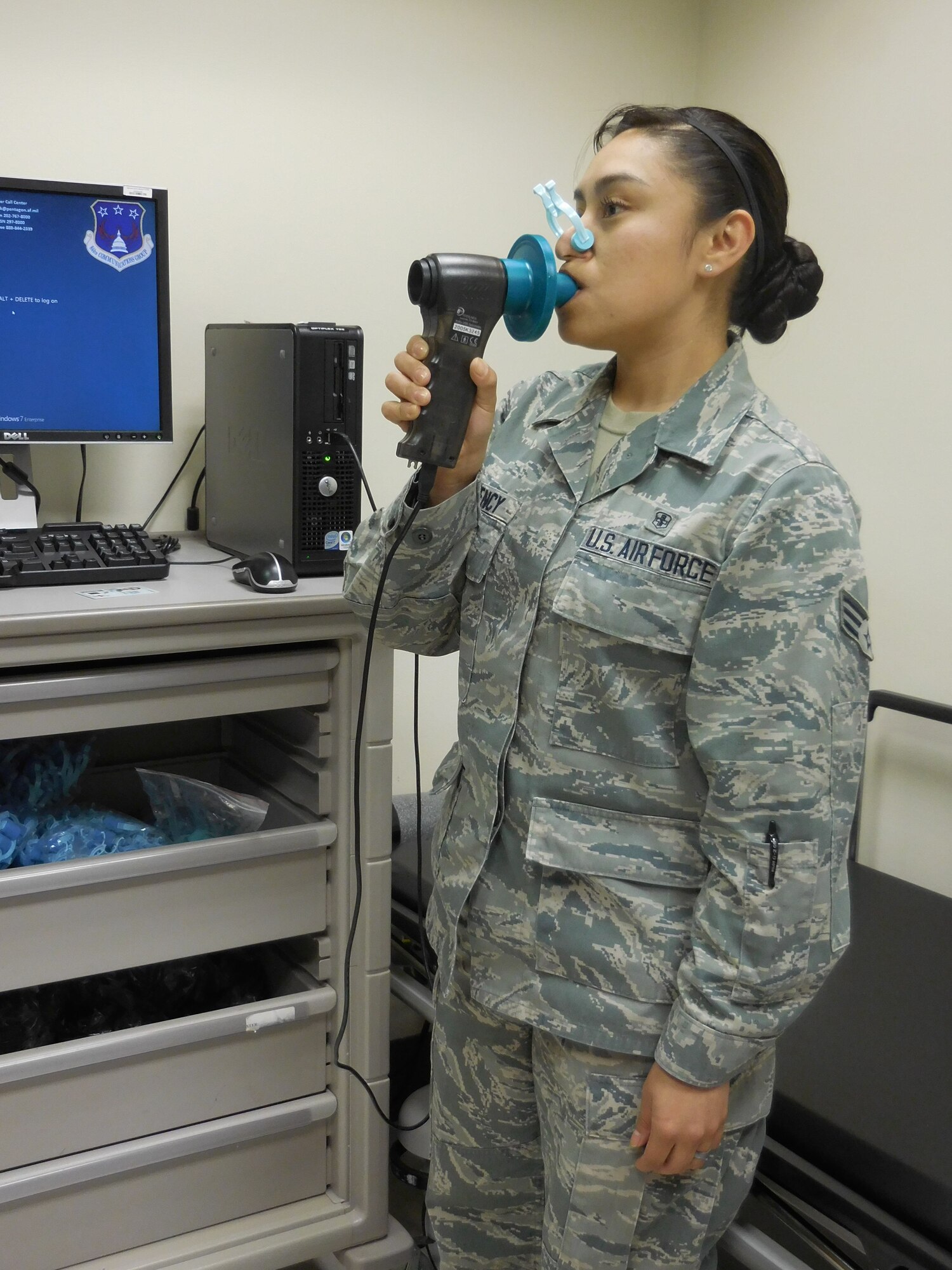 Senior Airman Nancy Morency demonstrates a pulmonary function test, which measures how well you’re able to breathe and is used to monitor asthma. (photo by Kathleen Canfield).