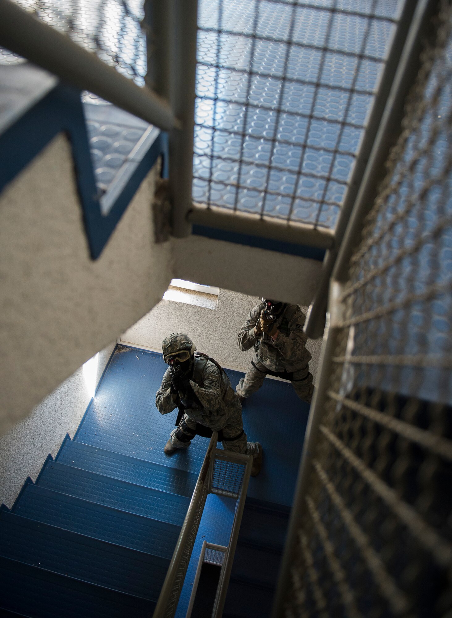 Staff Sgt. Steffan Roverud and Senior Airman Eric Beougher, 569th U.S. Forces Police Squadron patrolmen, clear a stairwell during an active-shooter training on Vogelweh Military Complex, Germany, May 5, 2016. During the training the Airmen were required to move through a building in a two-man team to locate the simulated active shooter. (U.S. Air Force photo/Senior Airman Damon Kasberg)