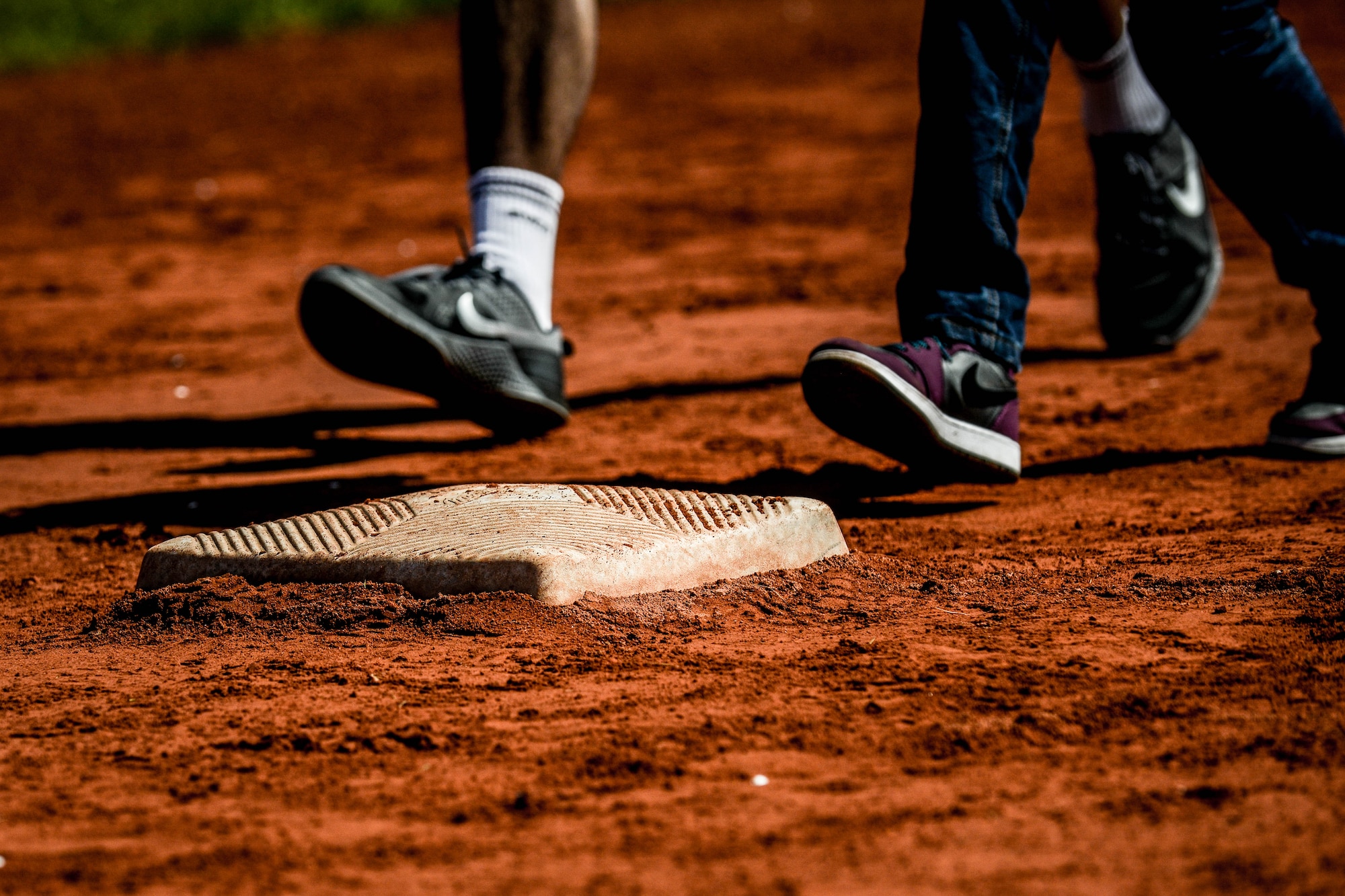 A student and volunteer run to a base during an adaptive-sports softball game May 2, 2016, at Ramstein Air Base, Germany.  Students from Kaiserslautern and Ramstein middle and high schools paired up with volunteers from the local Guzzlers soft-ball team to participate in the event. (U.S. Air Force photo/Senior Airman Nicole Keim)