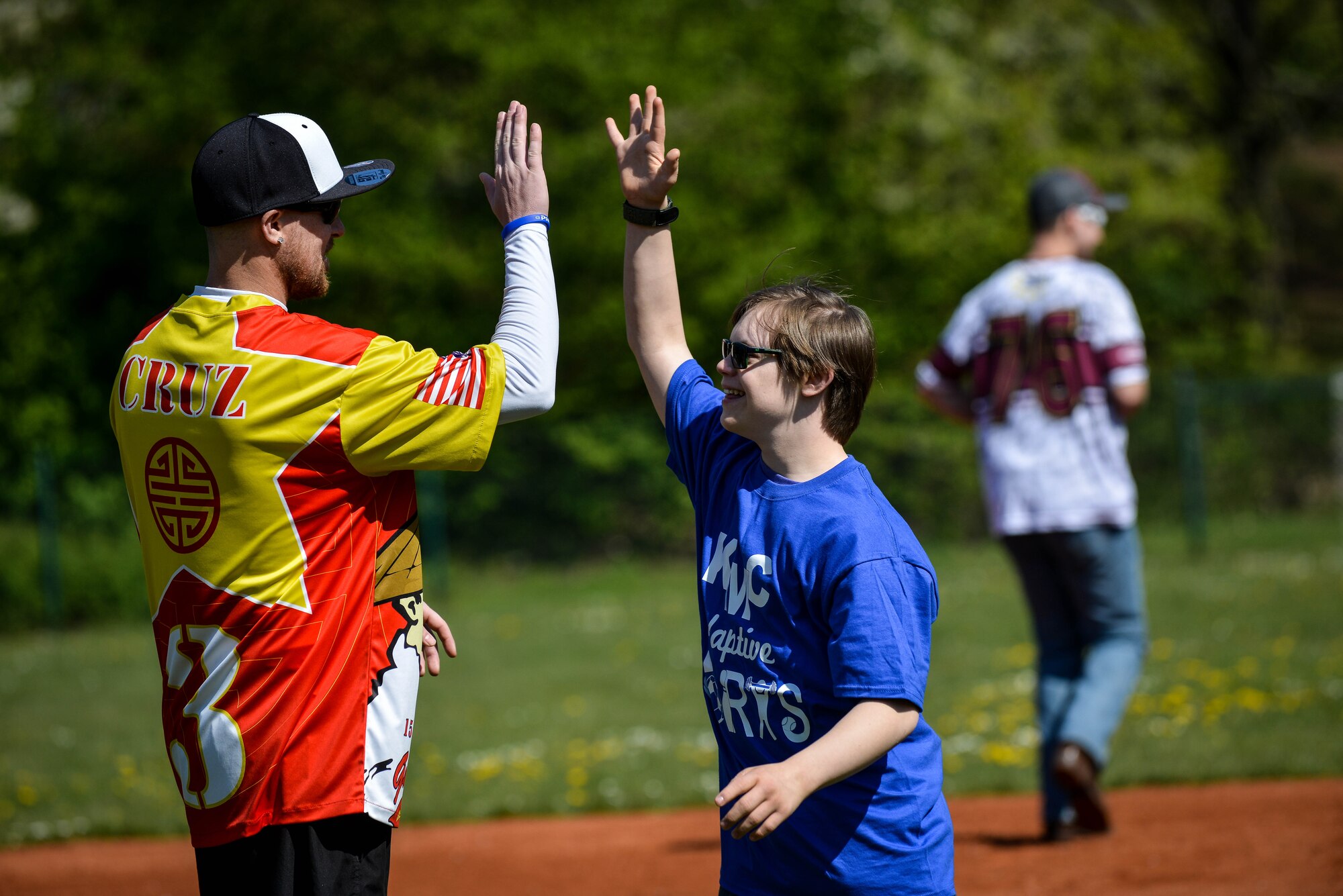 Nick Waller, Guzzler’s softball player and volunteer high-fives James Lucas, Ramstein Middle School student during an adaptive-sports softball game May 2, 2016, at Ramstein Air Base, Germany.  The adaptive-sports games held throughout the year give special-needs students a chance to come together to learn both social and physical skills. (U.S. Air Force photo/Senior Airman Nicole Keim)