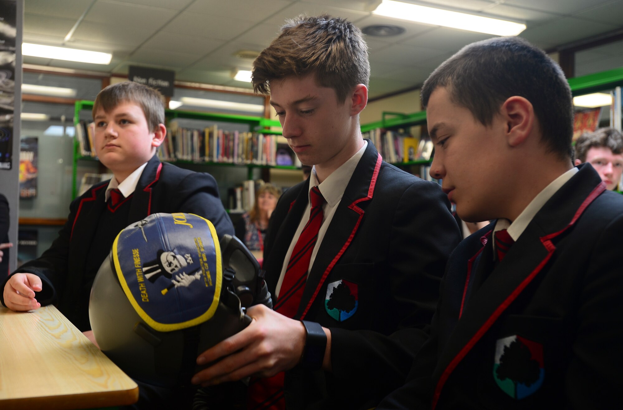 Students from Mildenhall College Academy, England, inspect an F-22 Raptor pilot’s helmet during a visit from 95th Fighter Squadron Airmen, May 6, 2016. The Airmen visited children in the local community to educate them about the U.S. Air Force mission and their respective career fields. (U.S. Air Force photo by Senior Airman Dawn M. Weber/Released)