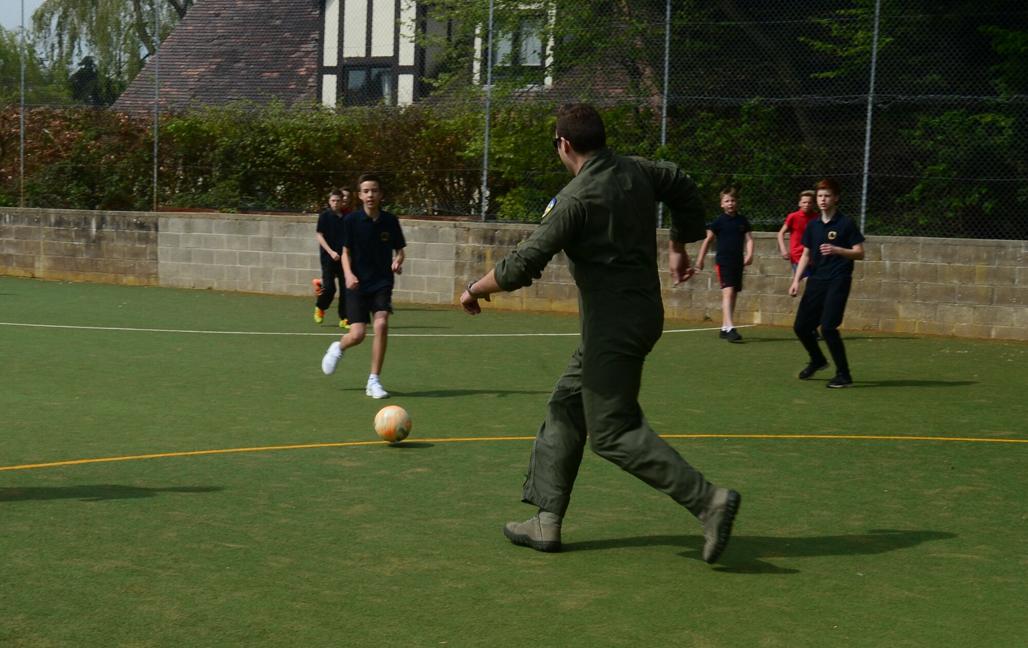 1st Lt. “Jolly” Foss, 95th Fighter Squadron F-22 Raptor pilot, plays football with year eight students at Mildenhall College Academy, England, May 6, 2016. During their deployment to the 48th Fighter Wing, Airmen visited local schools to educate students about the U.S. Air Force, aviation, and fitness, and to help the students gain a better understanding about the military lifestyle (U.S. Air Force photo by Senior Airman Dawn M. Weber/Released)