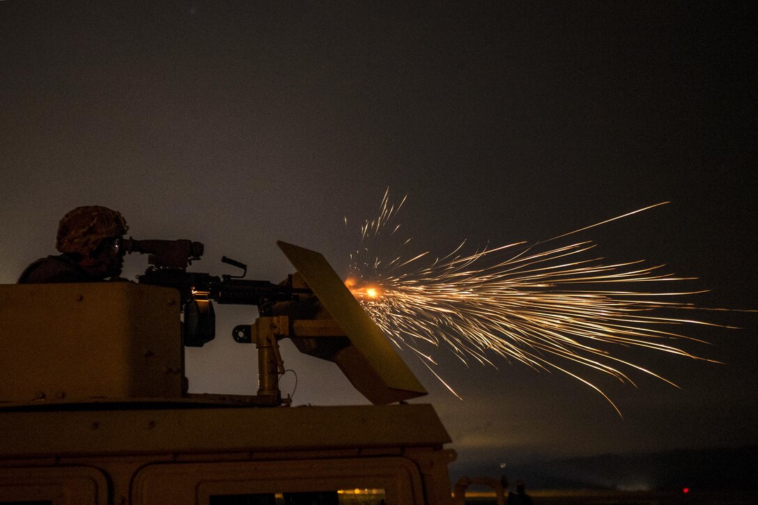 An Army Reserve soldier fires an M249 automatic weapon mounted on a high-mobility vehicle turret during a night-fire qualification at Fort Hunter-Liggett, Calif., May 4. The soldier is assigned to the 341st Military Police Company. Army photo by Master Sgt. Michel Sauret