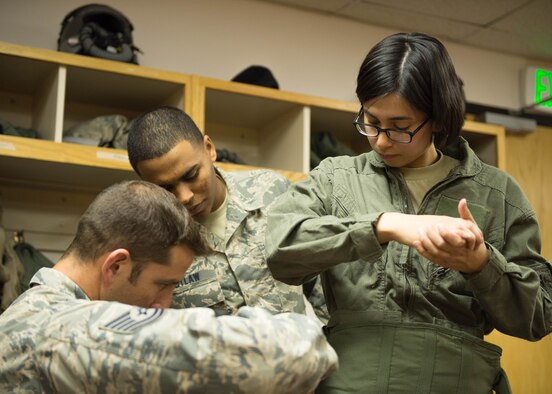 U.S. Air Force Airmen from the 354th Operations Support Squadron help Airman 1st Class Victoria Ortaleza, a 354th Aircraft Maintenance Squadron electronic and environmental systems journeyman, don a gravity suit prior to a familiarization flight May 4, 2016, at Eielson Air Force Base, Alaska. Ortaleza was recommended by her leadership for the flight to learn the impacts of her contribution to the flying mission. (U.S. Air Force photo by Staff Sgt. Shawn Nickel/Released) 