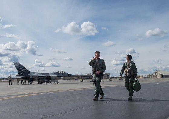 U.S. Air Force Maj. Michael Kuzmuk, an 18th Aggressor Squadron pilot, and Airman 1st Class Victoria Ortaleza, a 354th Aircraft Maintenance Squadron electronic and environmental systems journeyman, walk to the F-16D Fighting Falcon aircraft they will fly in at Eielson Air Force Base, Alaska, May 4, 2016 during a RED FLAG-Alaska 16-1 sortie. With more than 500 tactical flying hours logged during each RF-A, maintainers work around the clock on various systems, each requiring a specialized Airman like Ortaleza who is responsible for working on the environmental control systems, which controls pressurization, heating and cooling throughout the equipment and cockpit, as well as oxygen systems. (U.S. Air Force photo by Staff Sgt. Shawn Nickel/Released) 
