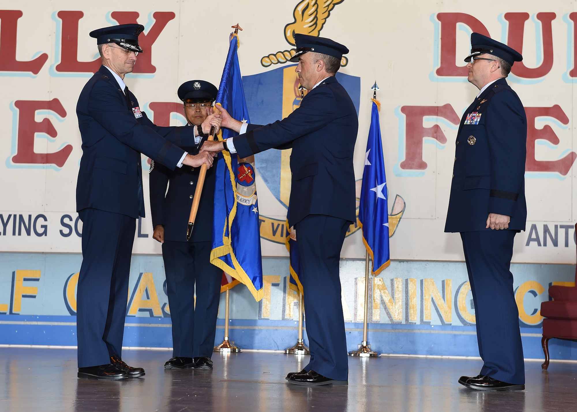 Lt. Gen. Mark A. Ediger (left), Surgeon General of the Air Force, passes the Air Force Medical Operations Agency guidon to Brig. Gen. Robert I. Miller (center), incoming AFMOA commander, during a May 6 change of command ceremony at Port San Antonio. In military tradition, the passing of a unit guidon signifies relinquishing or accepting command of that unit. (U.S. Air Force photo / Tech. Sgt. Christopher Carwile.)
