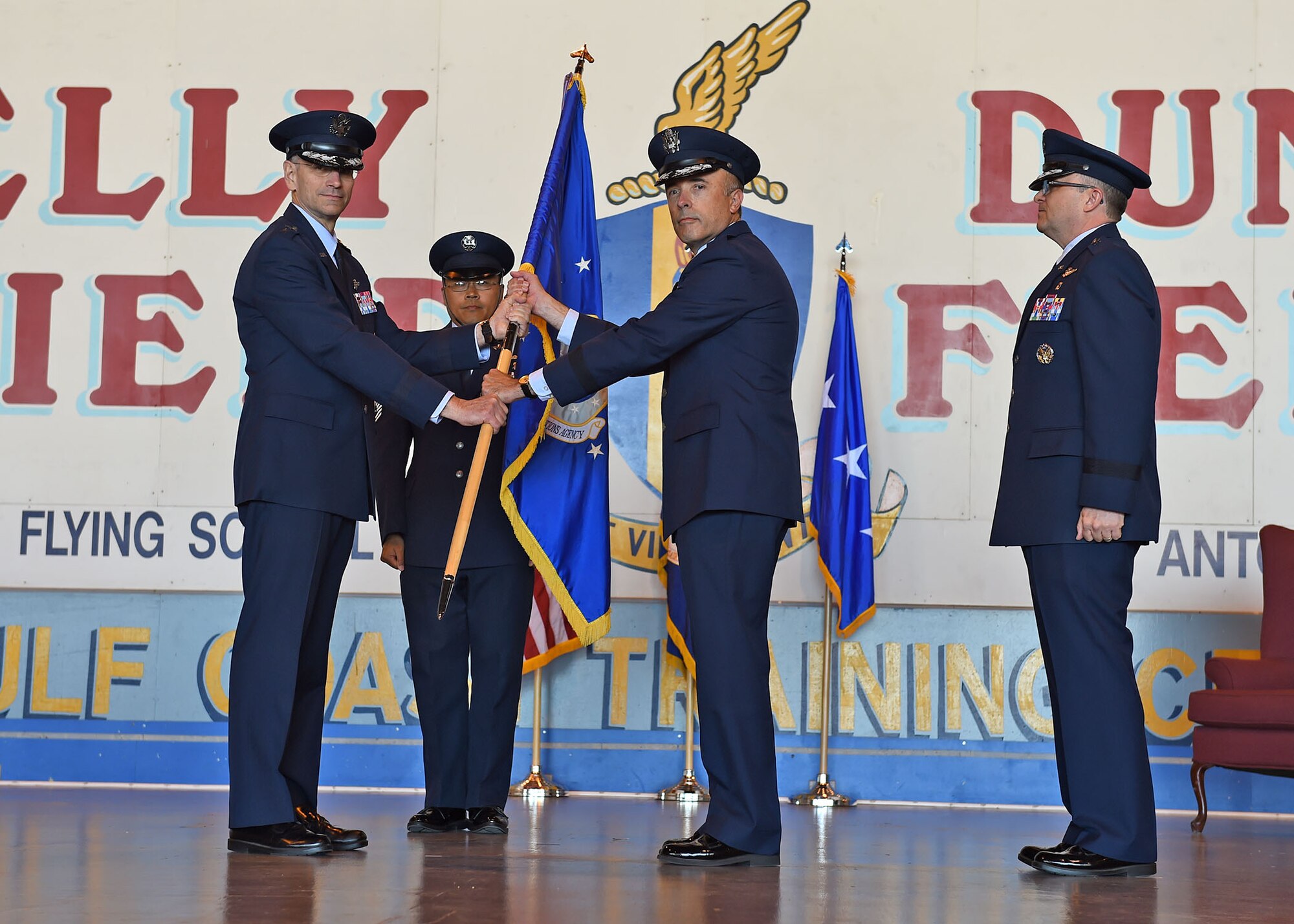Lt. Gen. Mark A. Ediger (left), Surgeon General of the Air Force, passes the Air Force Medical Operations Agency guidon to Brig. Gen. Robert I. Miller (center), incoming AFMOA commander, during a change of command ceremony at Port San Antonio, May 6. In military tradition, the passing of a unit’s guidon signifies relinquishing or accepting command of that unit. (U.S. Air Force photo / Tech. Sgt. Christopher Carwile.)