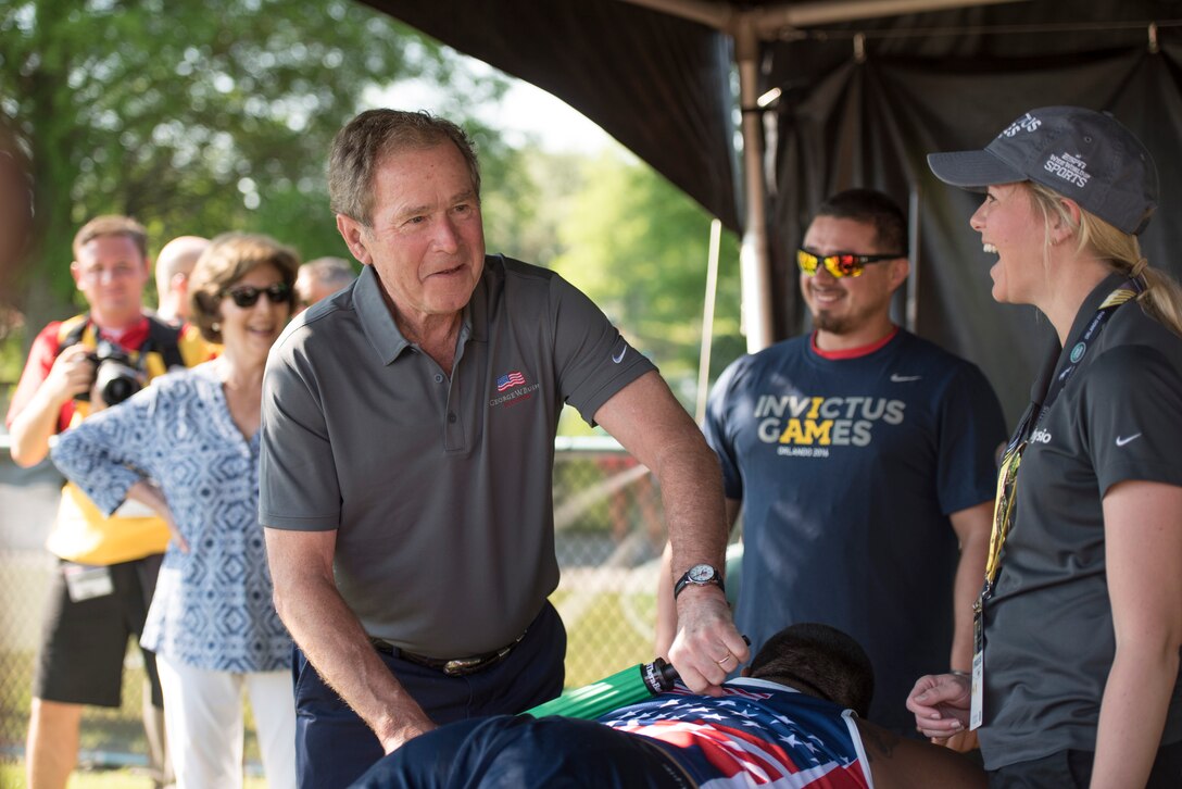 Former President George W. Bush, left, helps Marine Corps veteran Alex Nguyen, a member of the U.S. team, stretch after competing in a   wheelchair rugby match at the Invictus Games 2016 in Orlando, Fla., May 8, 2016. DoD photo by Roger Wollenberg