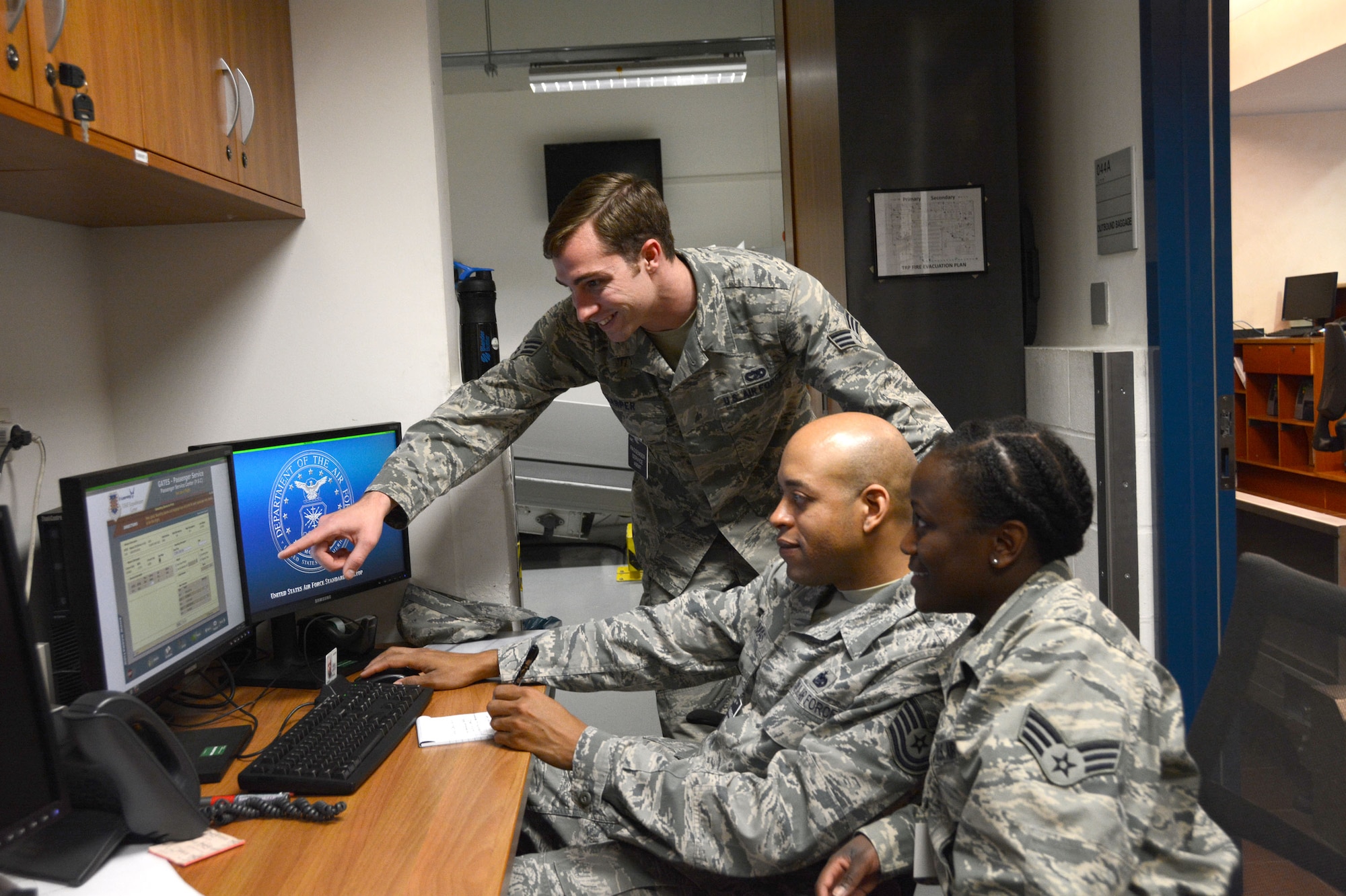 Senior Airman Thomas Harper (standing), 724th Air Mobility Squadron, guides Tech. Sgt. Steven Thomas (second from left) and Senior Airman Courtney Jackson, 71st Aerial Port Squadron, through passenger services standard operating procedures May 2, 2016 at Aviano Air Base, Italy. In any given month, the 724th AMS will service approximately 3,630 passengers who transit through its passenger terminal. (U.S. Air Force photo/Tech. Sgt. Mercedes Crossland)